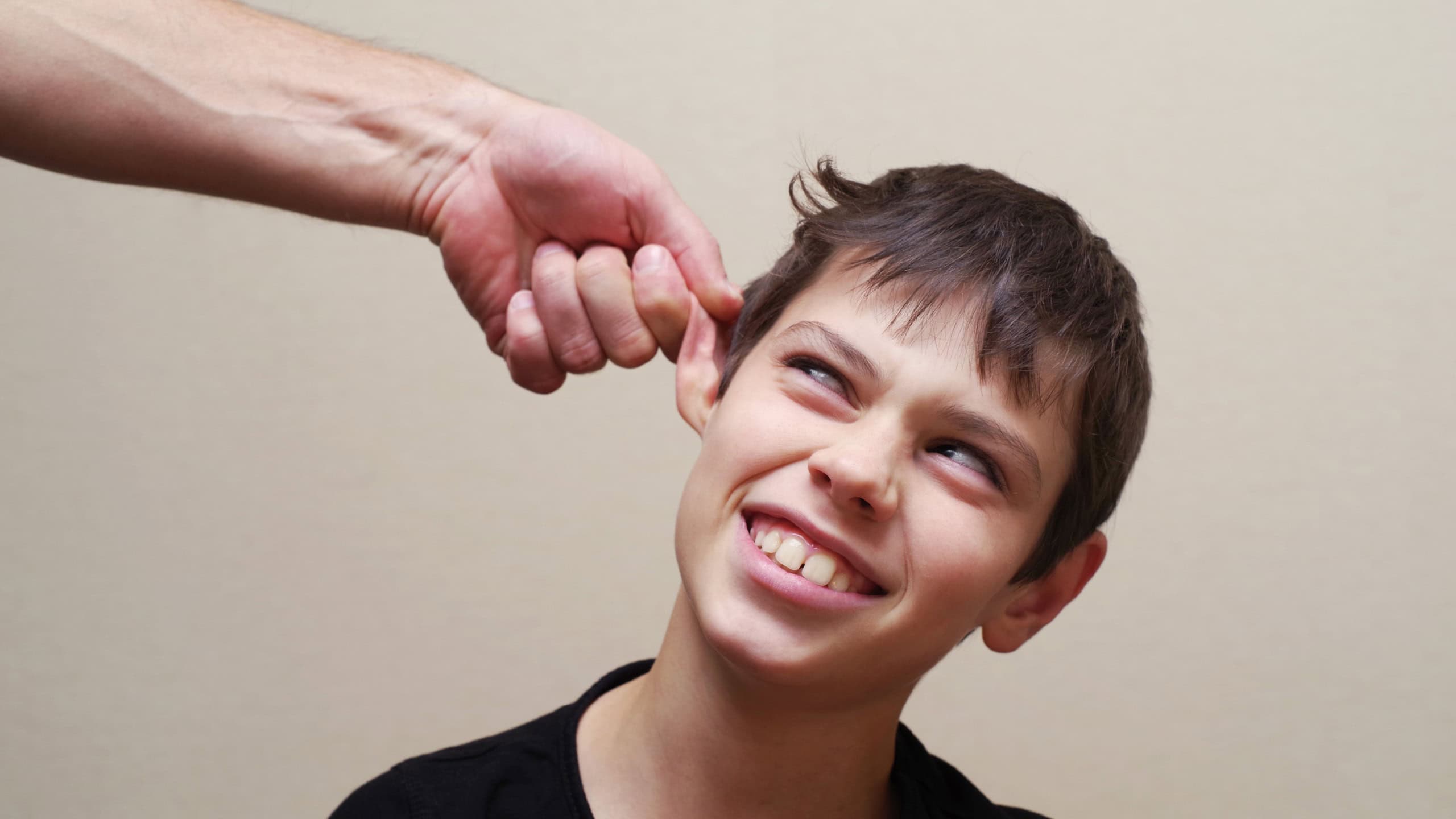 Boy receives physical punishment from the adult. Have grabbed by an ear.