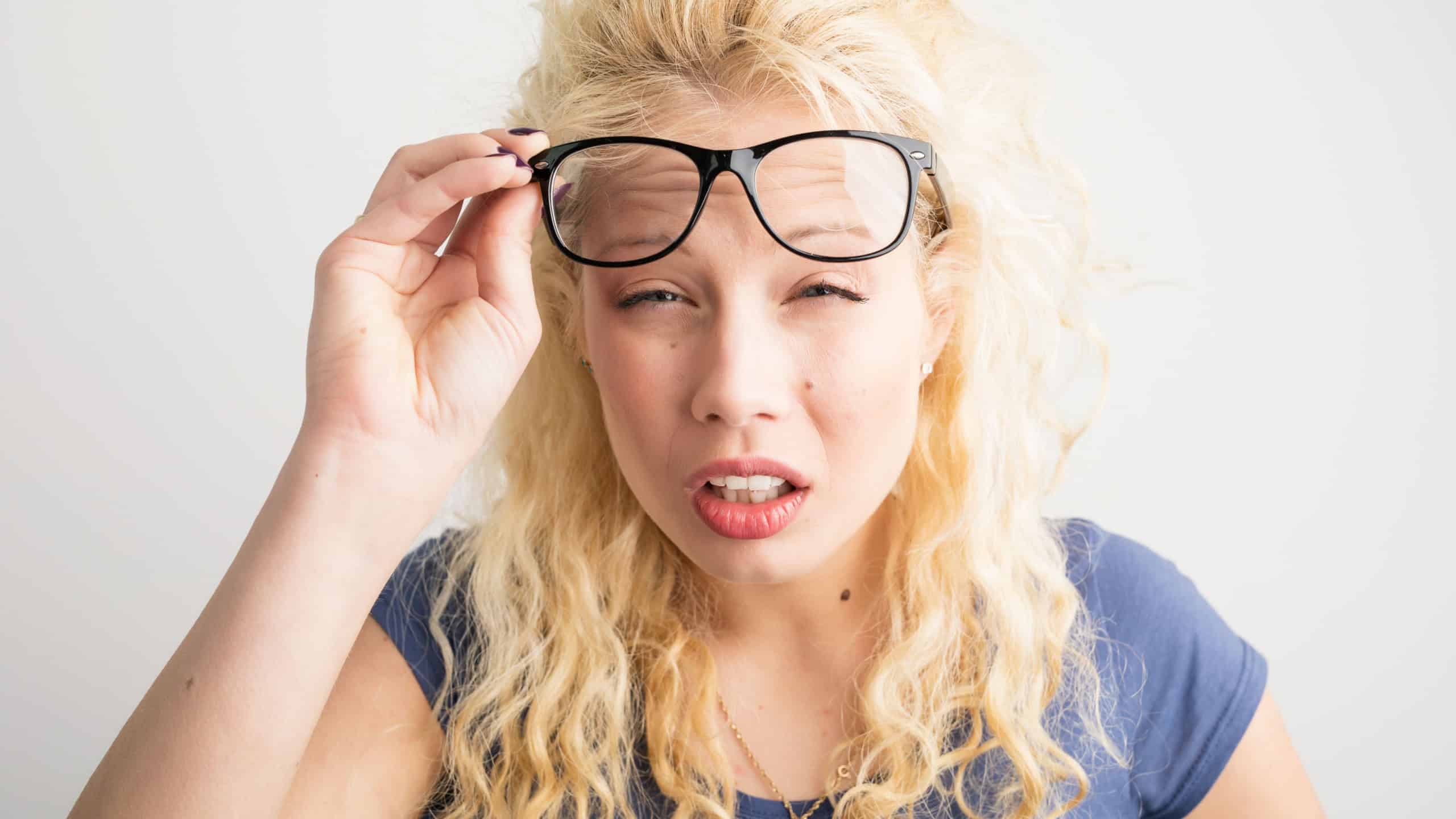 Woman with her glasses lifted up can't see