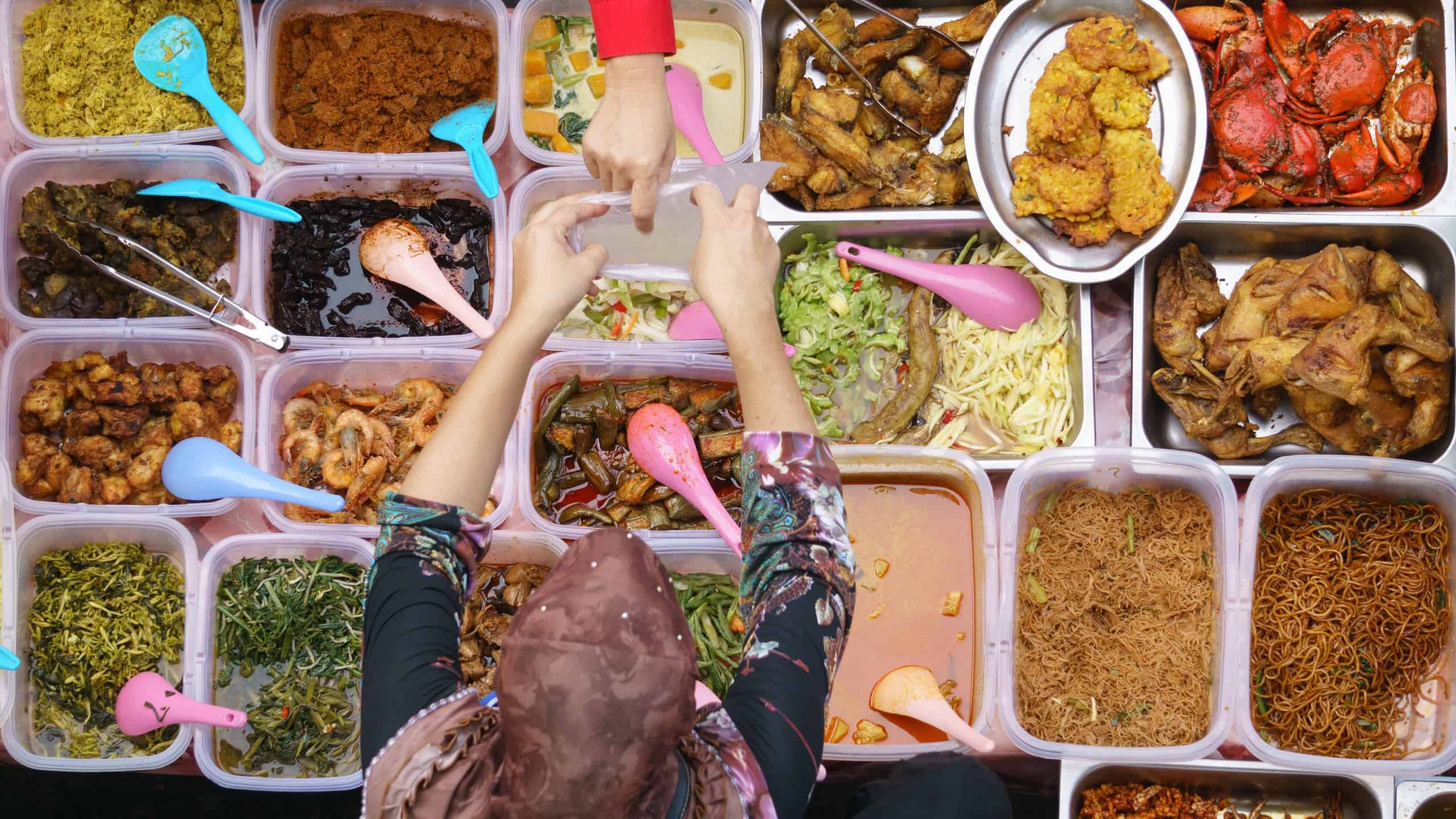 Variety of delicious Malaysian home cooked dishes sold at street market stall in Kota Kinabalu Sabah from top angle view.