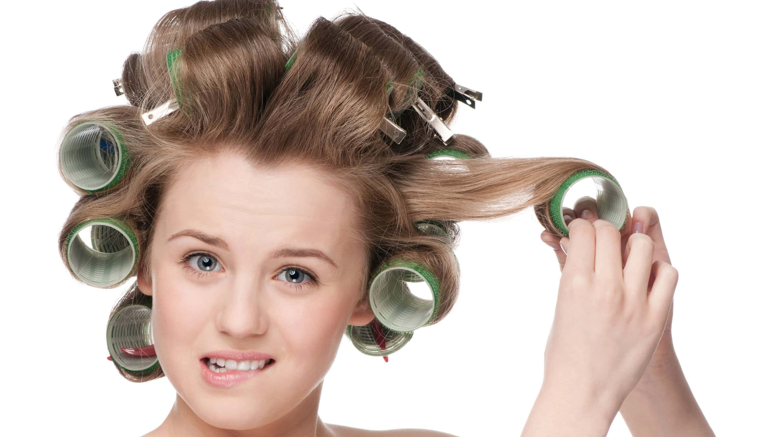 Beautiful woman curling her hair with roller