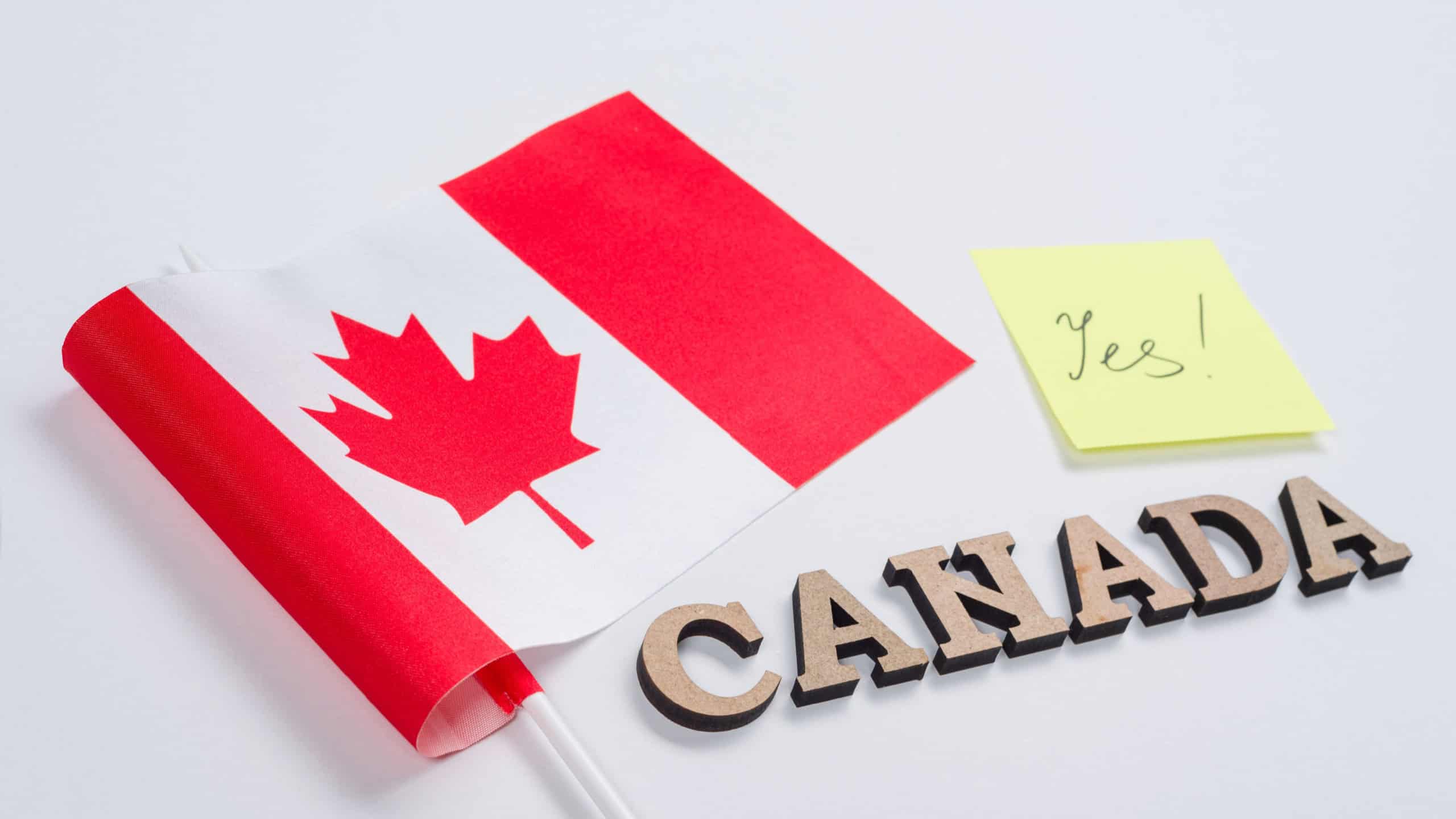 Flag of Canada, word Canada in wooden abstract letters, sticker with the inscription yes. White background.