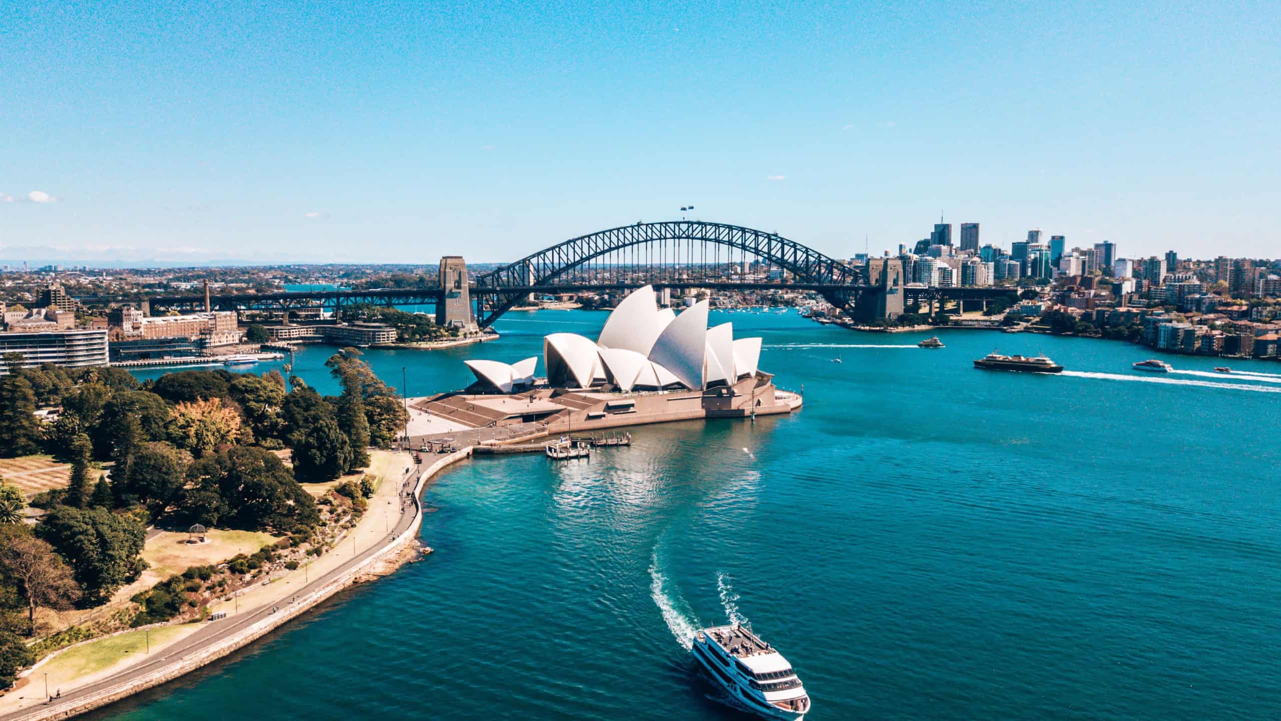 January 10, 2019. Sydney, Asutralia. Aerial view of the Sydney center by the park near Sydney Opera house, harbour bridge and city downtown. Small boats going past the opera house.