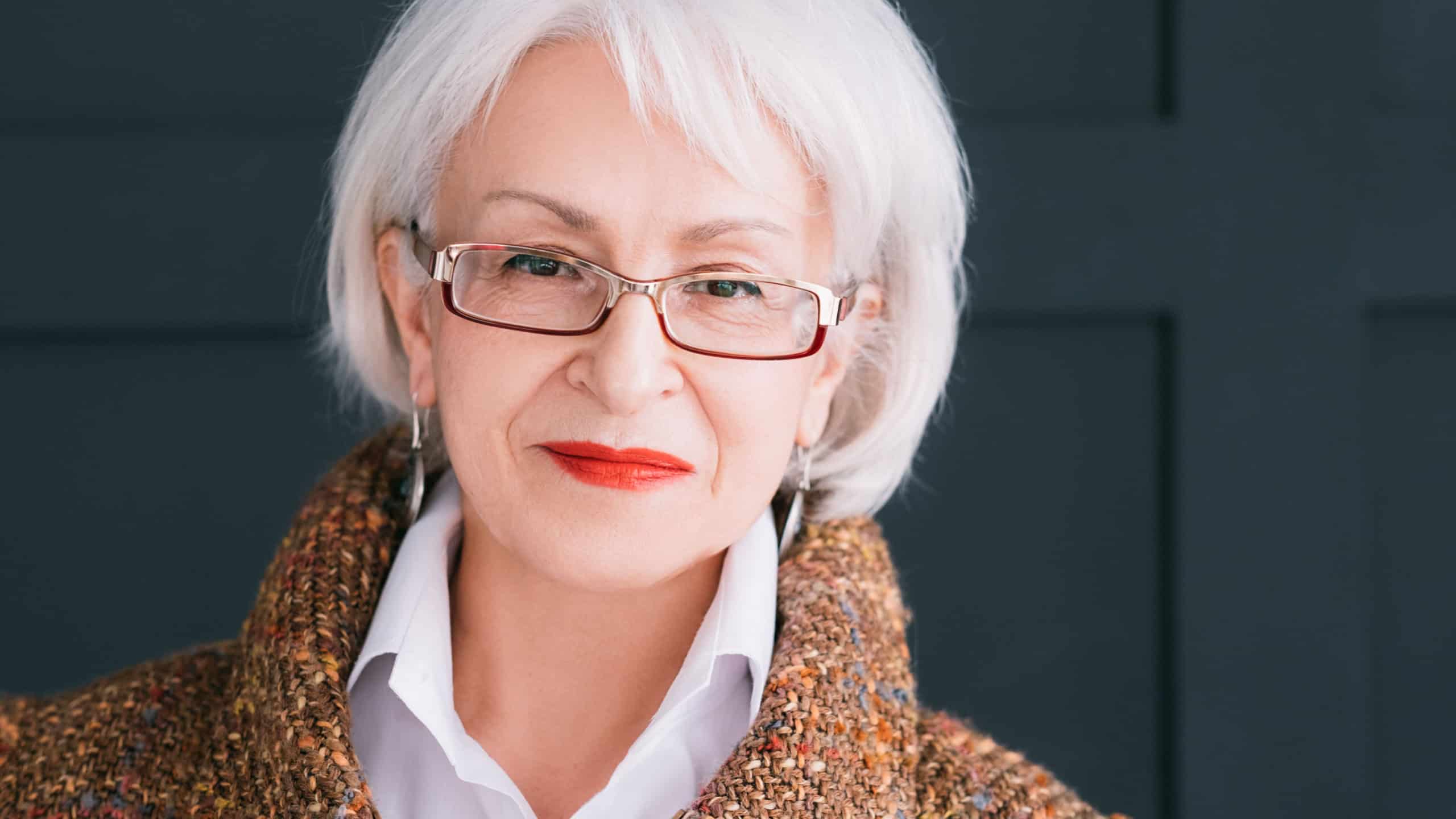 Senior fashion model portrait. Modern lifestyle. Stylish aged woman in autumn outfit looking at camera.