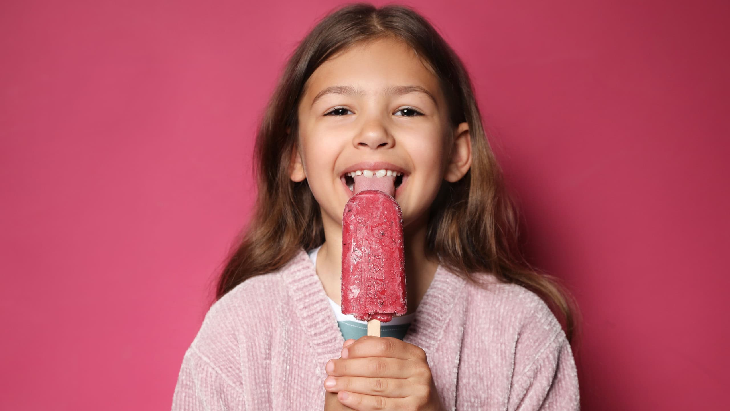 Adorable little girl with delicious ice cream against color background
