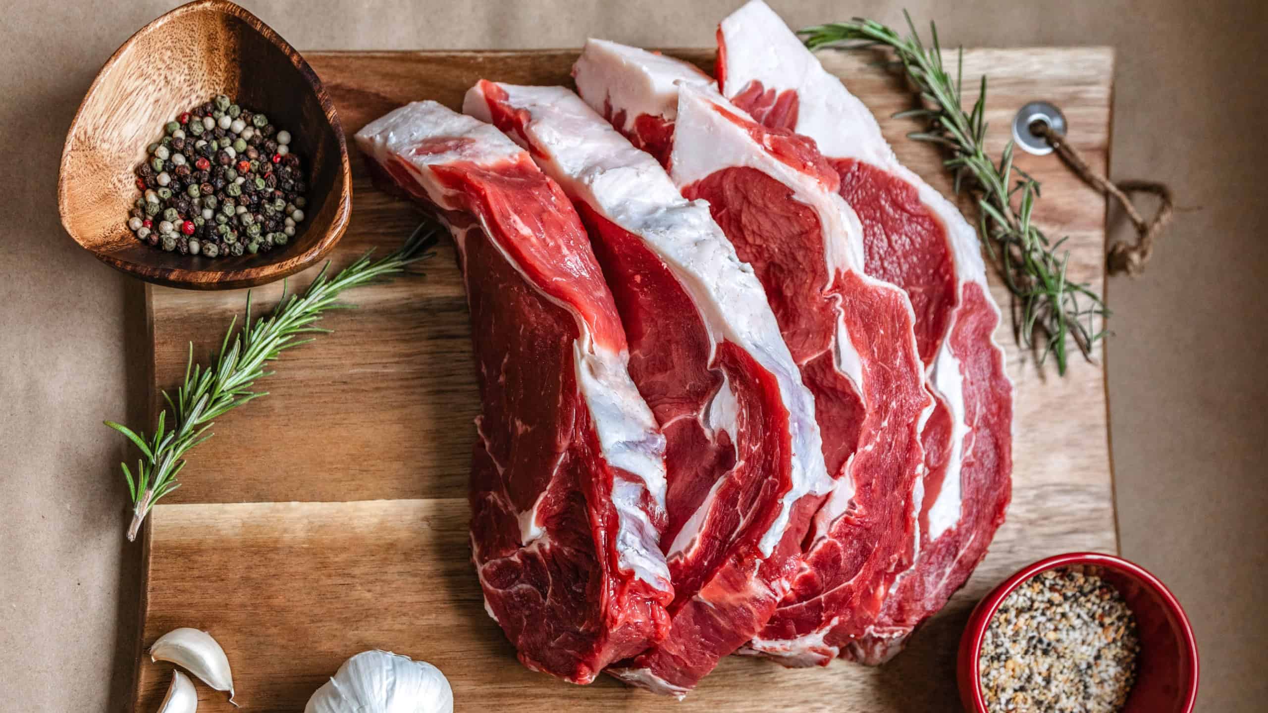 Organic grass-fed ribeye steak on wood board, paper background species. Beef Meat, raw meat. Canadian organic ribeye steak with an amazing taste. Ribeye is GMO, Steroid, Hormone and Antibiotic Free 