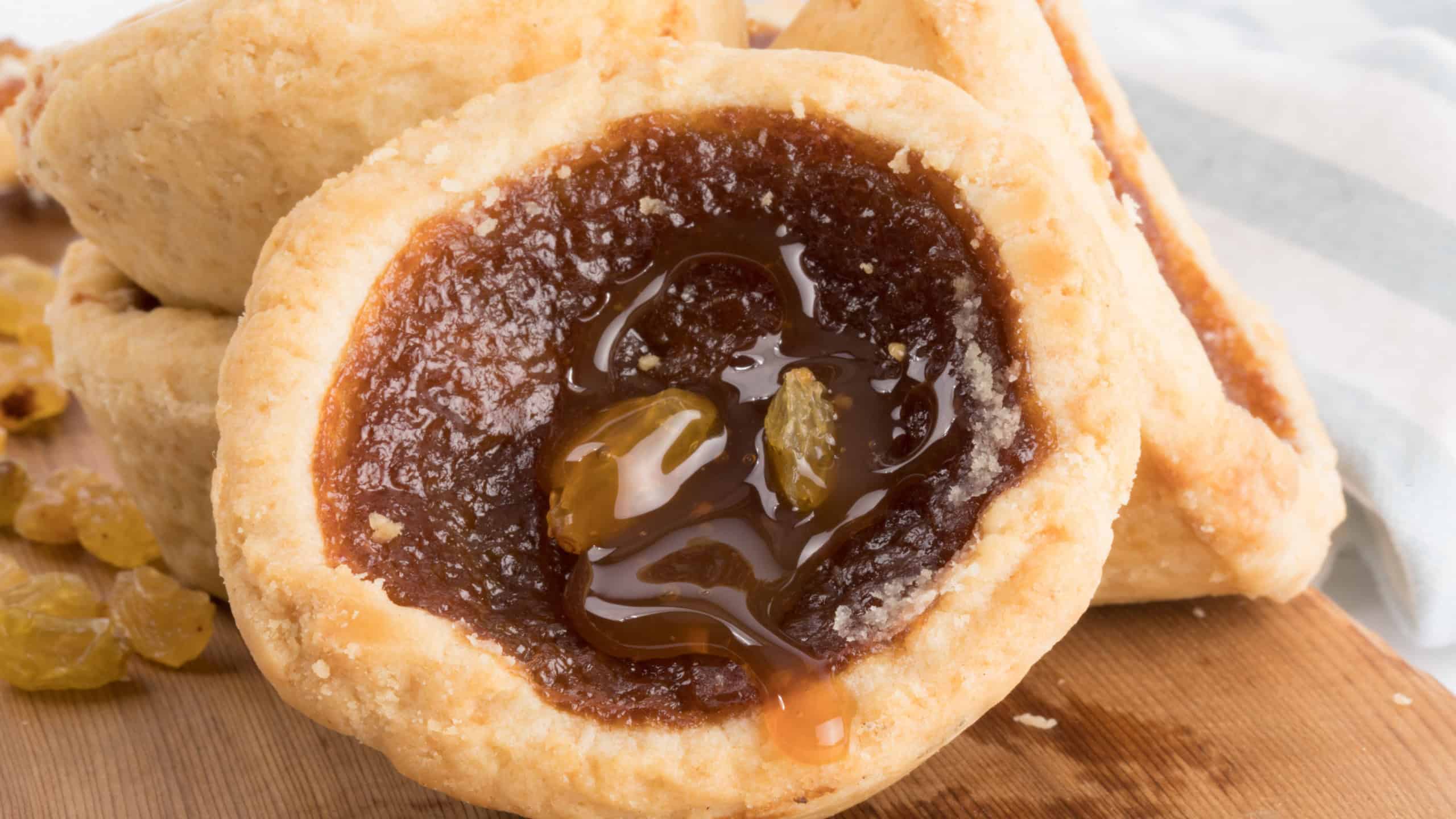 closeup view butter tarts lying against each other on a wooden board