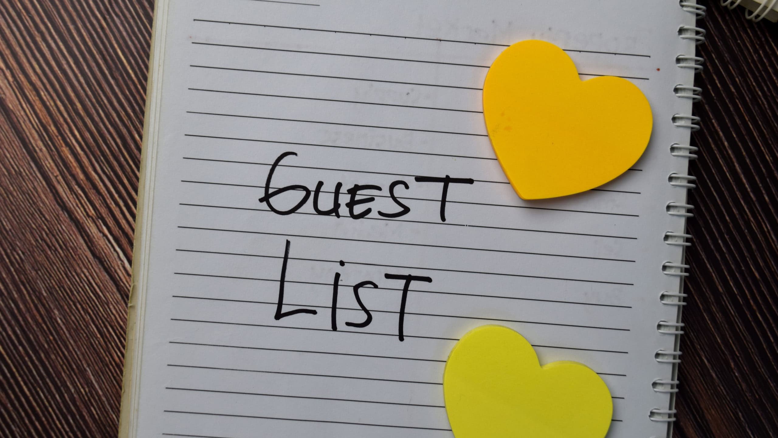Guest List write on a book with keywords isolated wooden table.