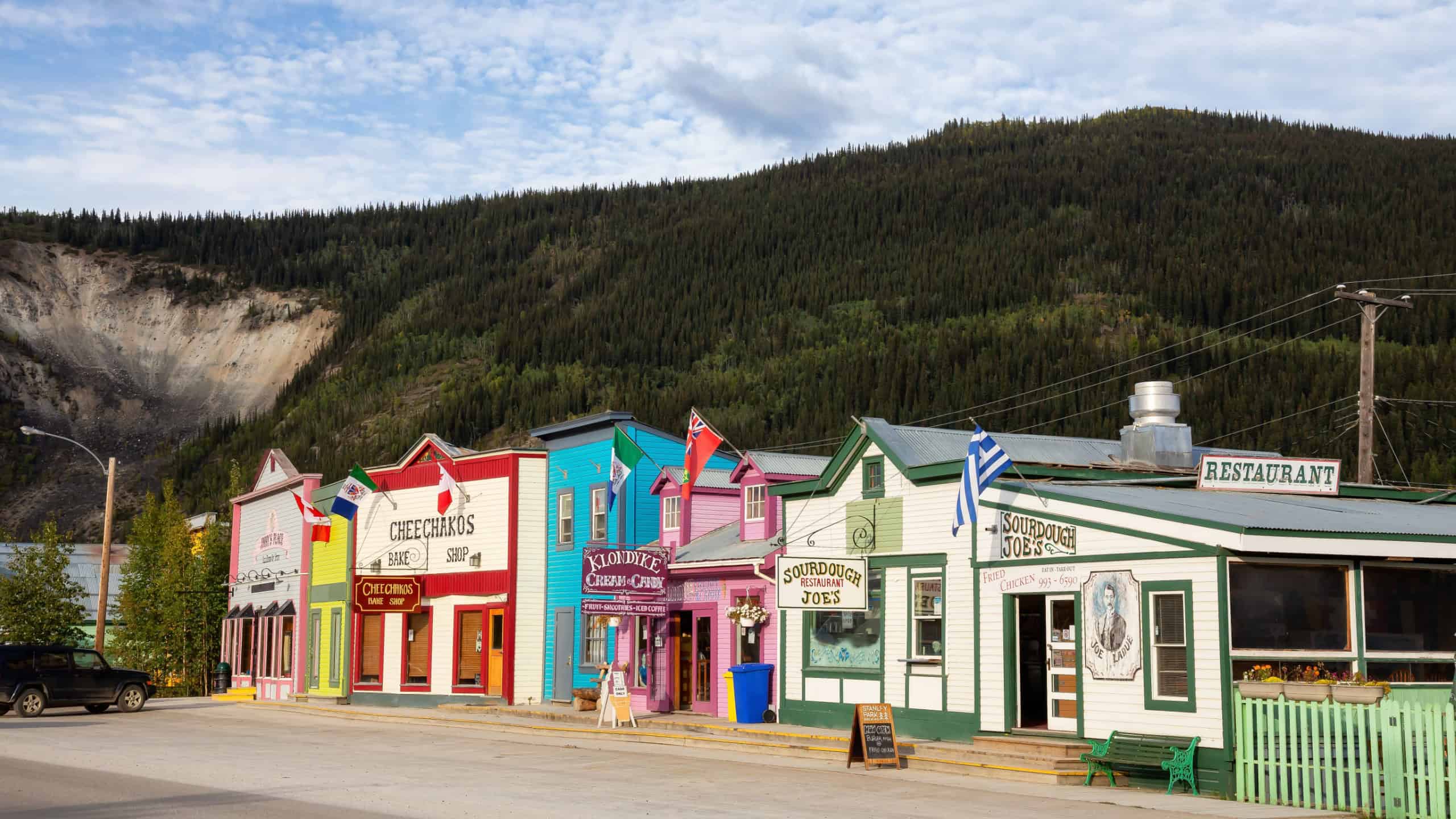 Dawson City, Yukon, Canada - August 27, 2020: Colorful Historic Buidings in a small touristic town during a cloudy summer day.