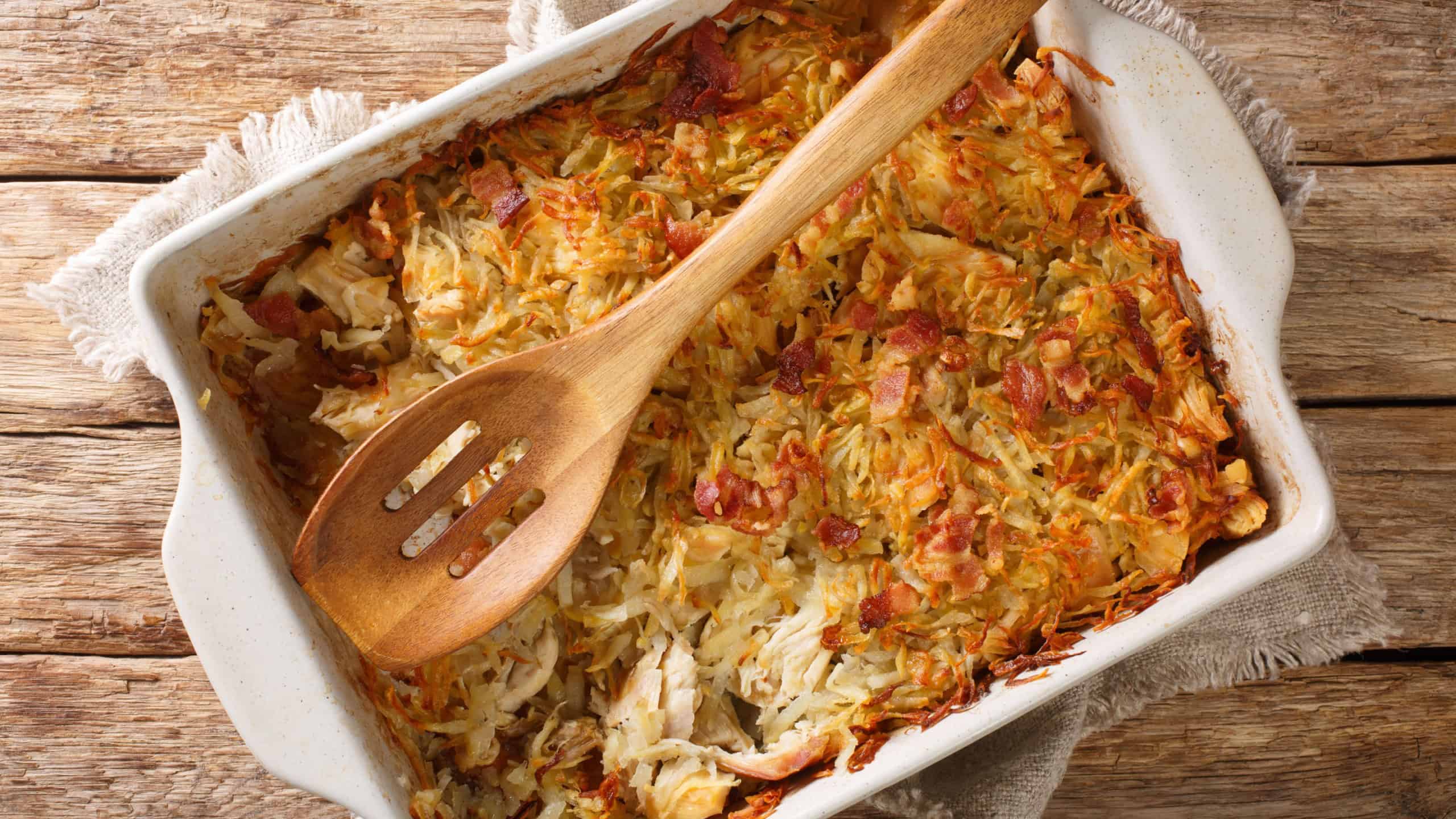 Canadian Rappie Pie, an Acadian classic comfort food dish made with grated potatoes and chicken closeup in a baking dish on the table. Horizontal top view from above