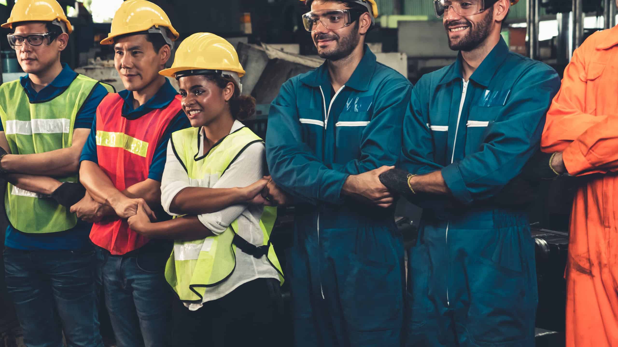 Skillful worker stand together showing teamwork in the factory . Industrial people and manufacturing labor concept .