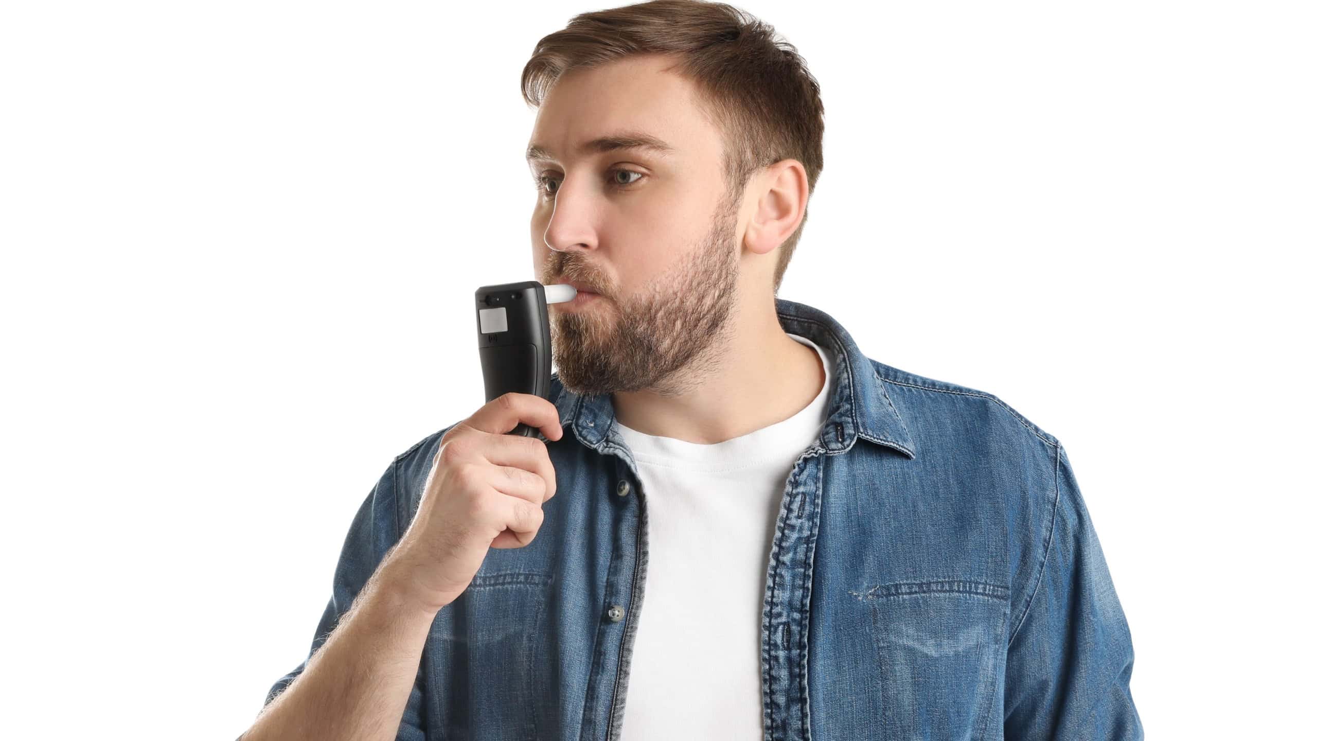 Man blowing into breathalyzer on white background