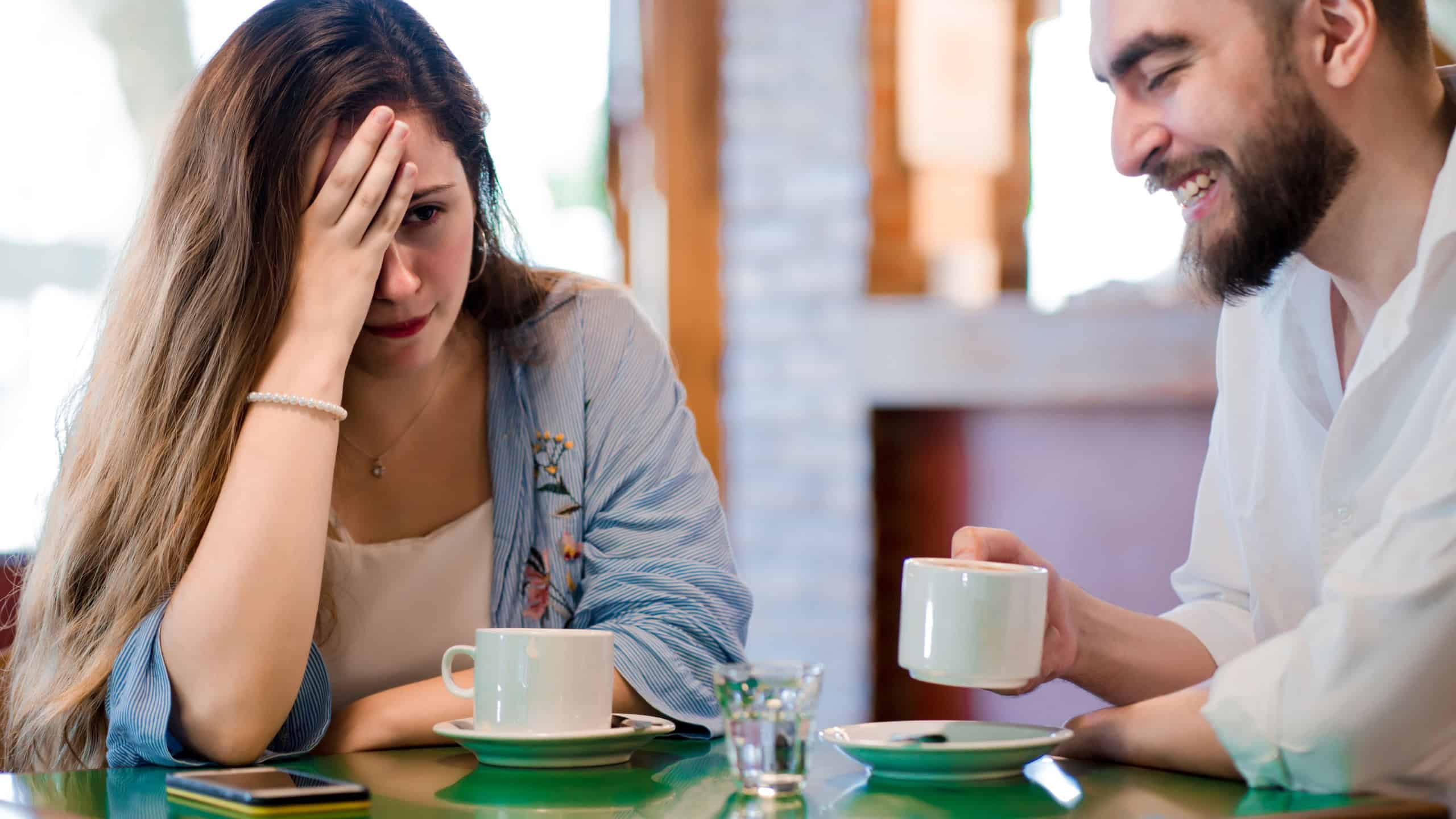 Woman getting bored at a date at a coffee shop.
