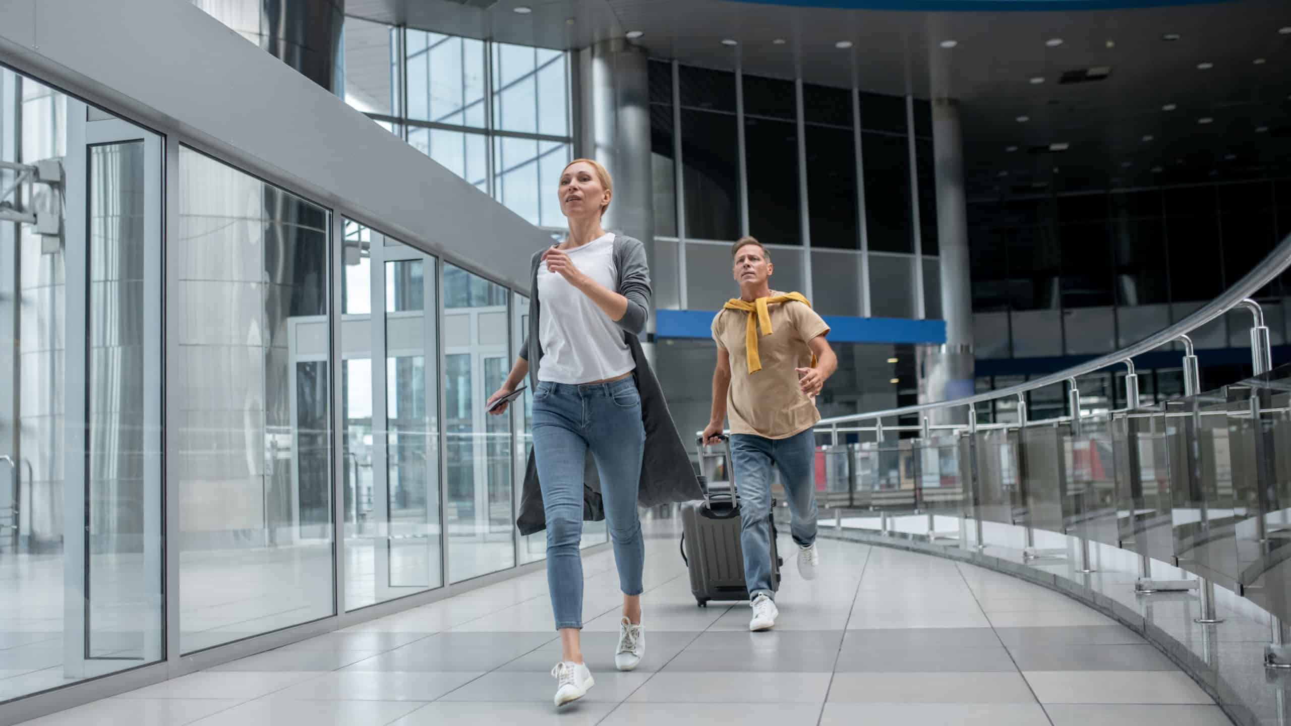 Two agitated passengers rushing through the airport terminal