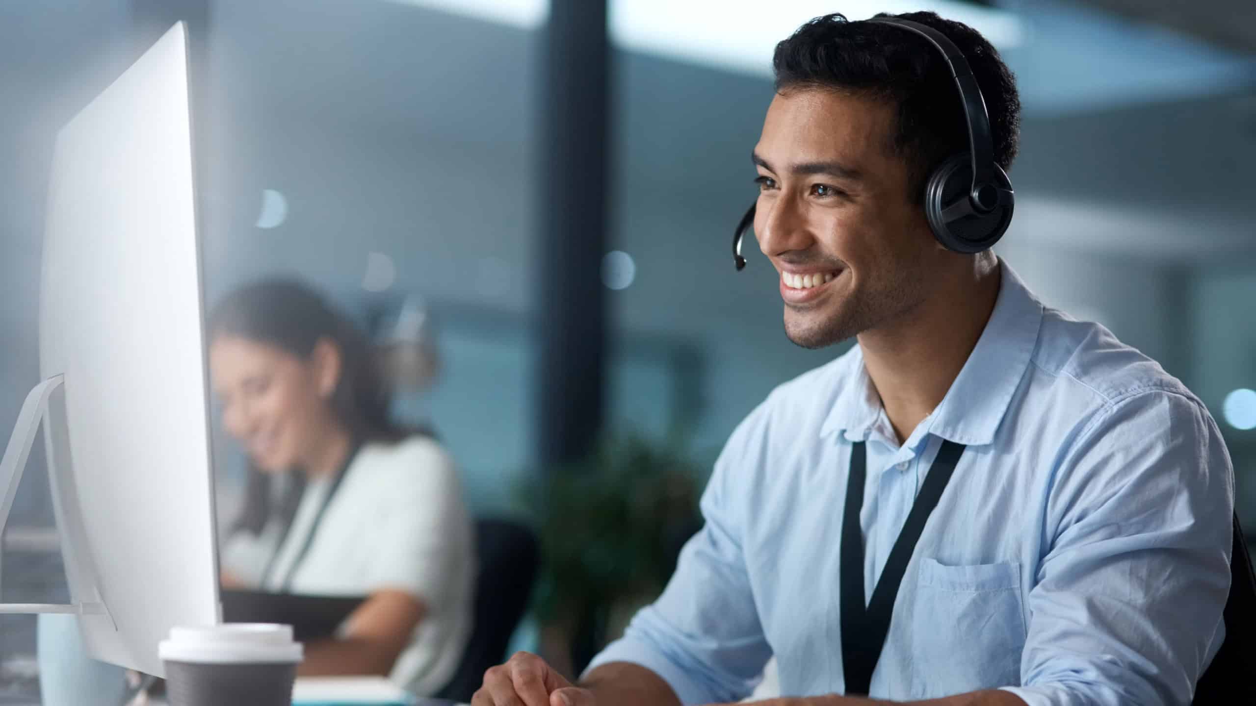Where would we be without loyal customers like you. Shot of a young man using a headset and computer in a modern office.