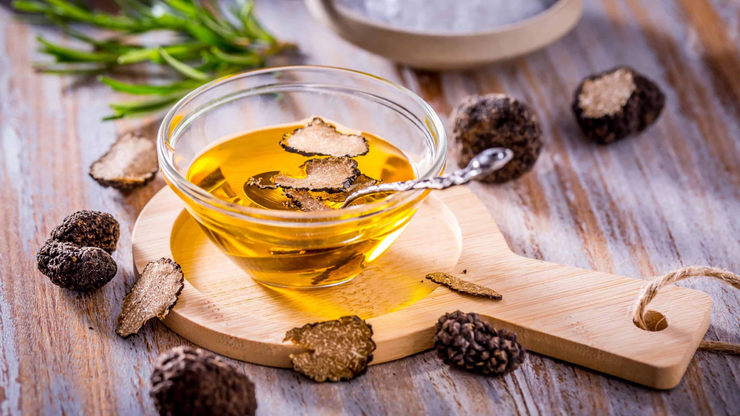 Truffle mushroom oil on wooden background. Gourmet food.
