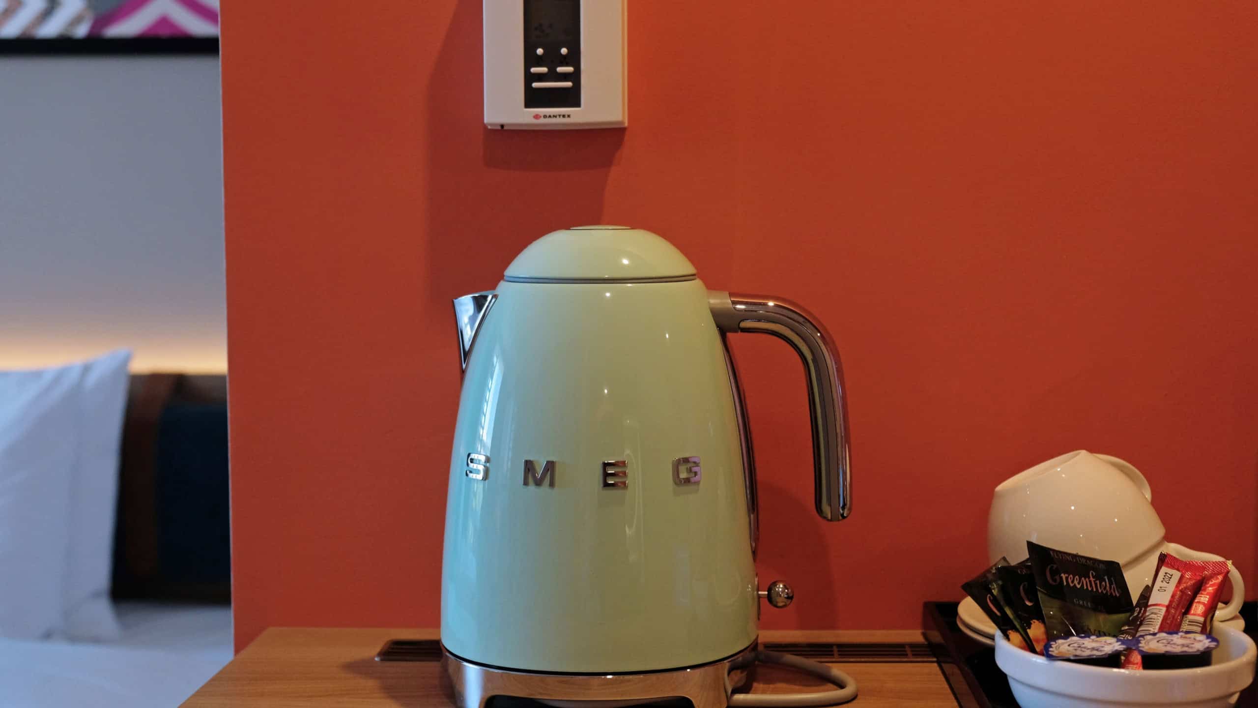 Green electric kettle SMEG for boiling water and making tea or coffee on table in hotel as design element. Household kitchen appliances for makes hot drinks. Moscow - July, 2022.