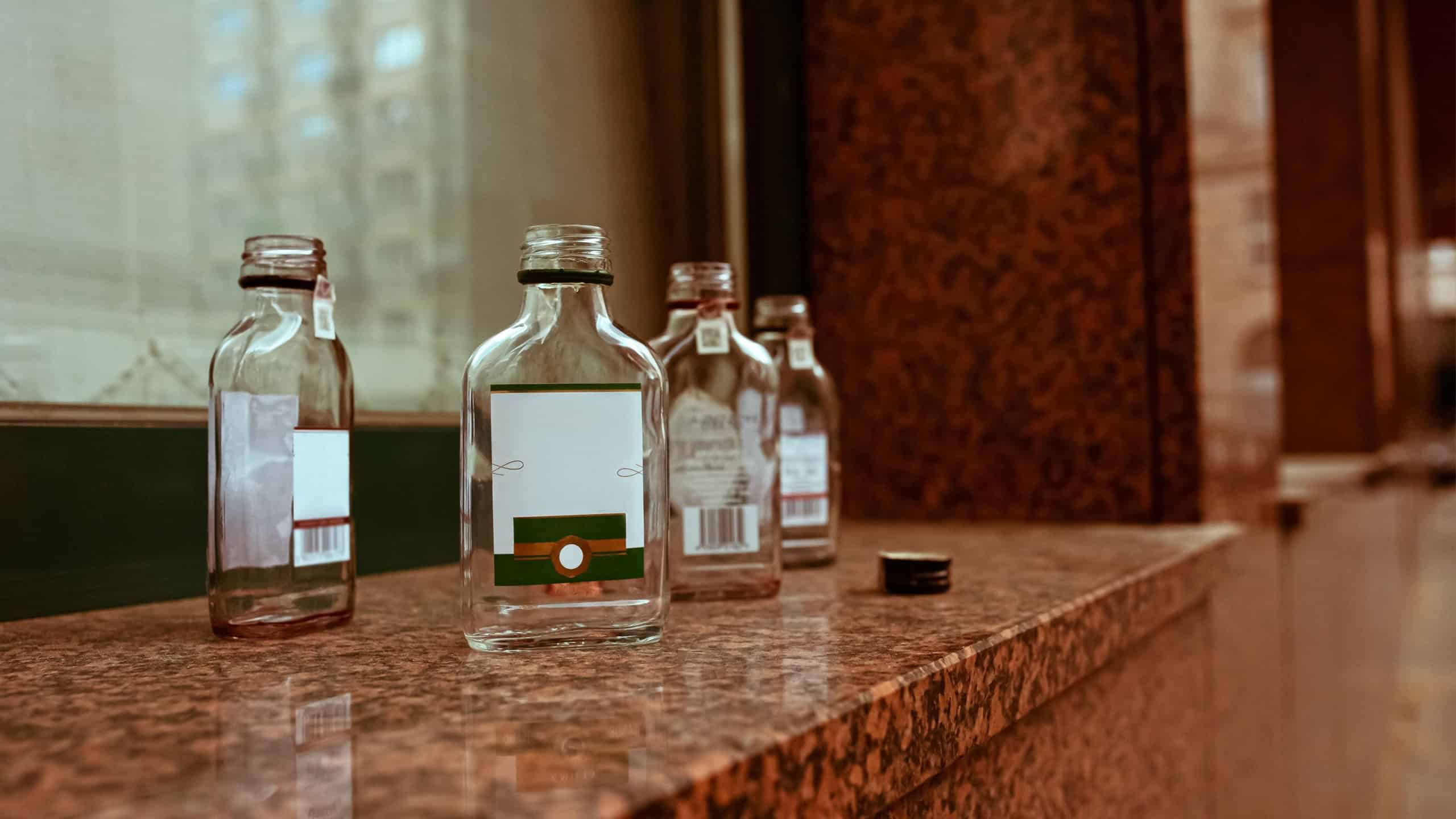 Many small glass bottles near window outdoors