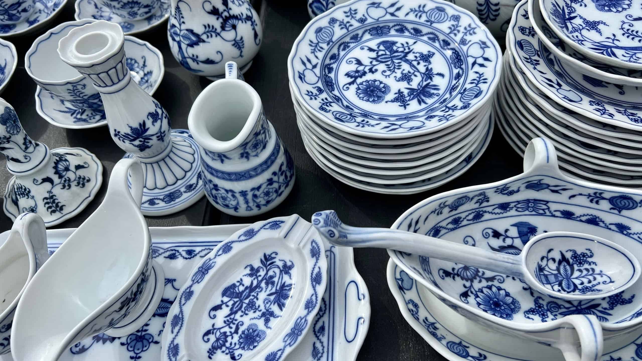 Plates, heap or stack of blue and white porcelain plates and dishes on table. china porcelain in a flea market. retro or vintage objects
