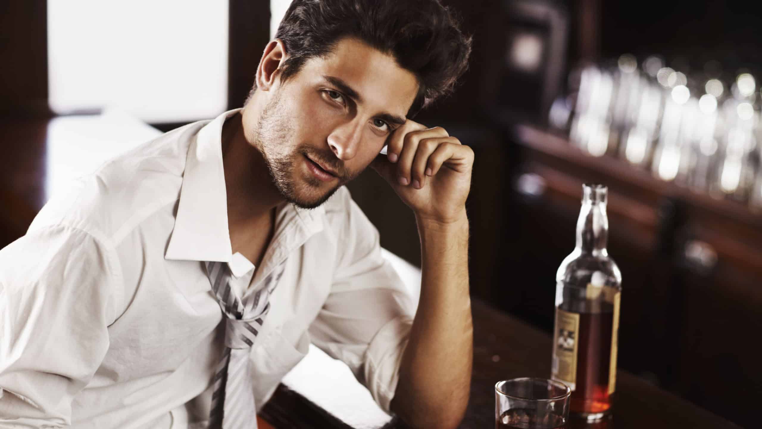 Business man, drinking and portrait in happy hour at a bar with alcohol and whiskey after work. Bottle, male person and face in a restaurant with a playboy guy and a glass and confidence in pub