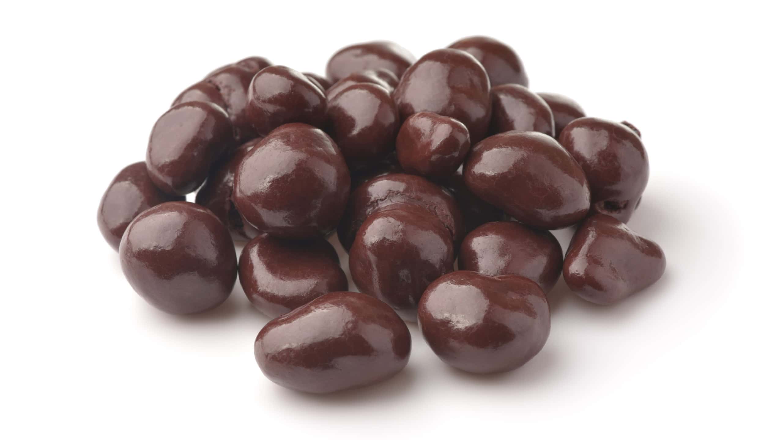 Heap of dark chocolate covered raisins isolated on white
