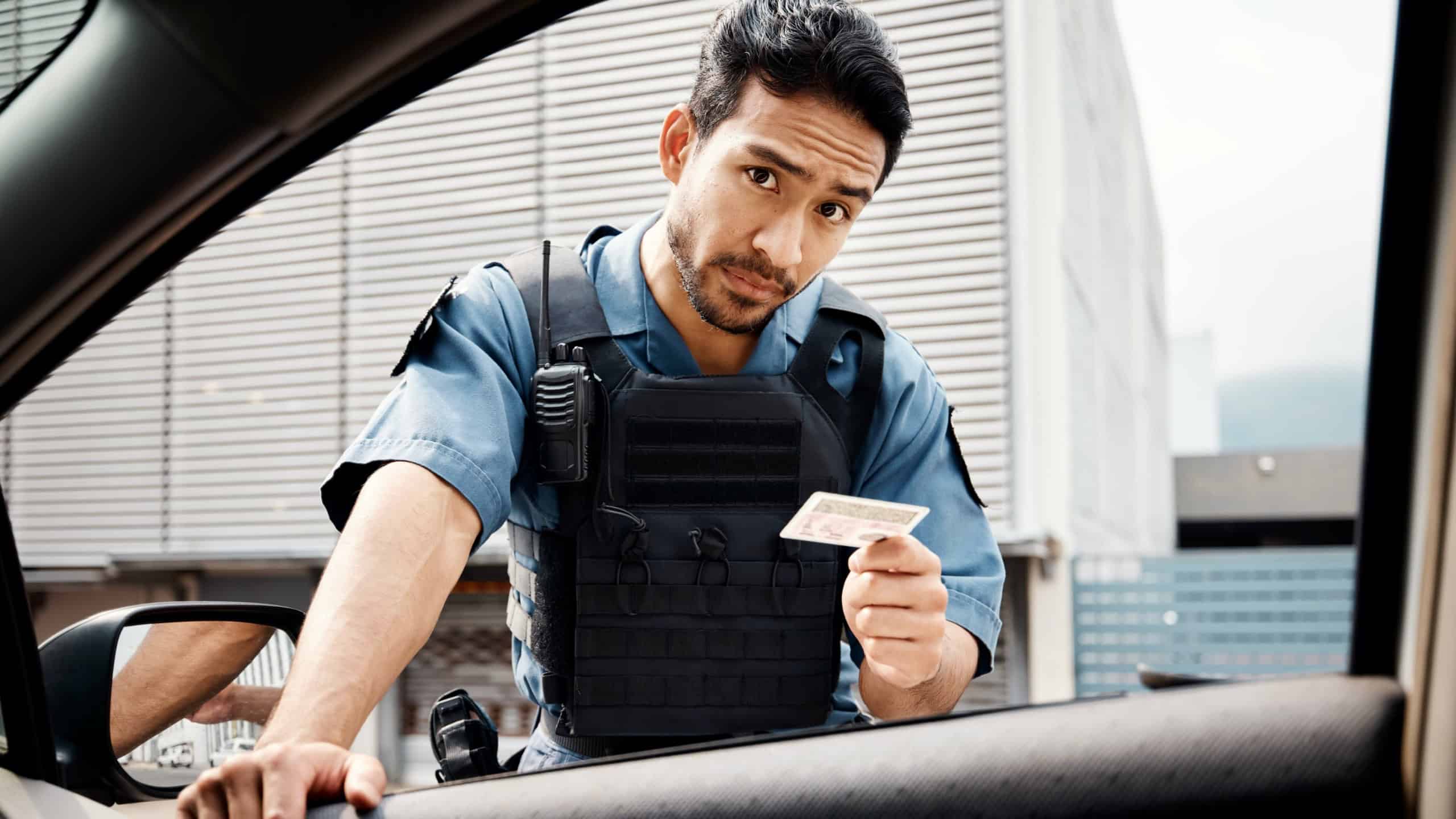 Car, drivers license or police officer in city to check info for law enforcement, protection or street safety. Cop portrait, traffic stop or security guard on patrol in a town for crime or justice