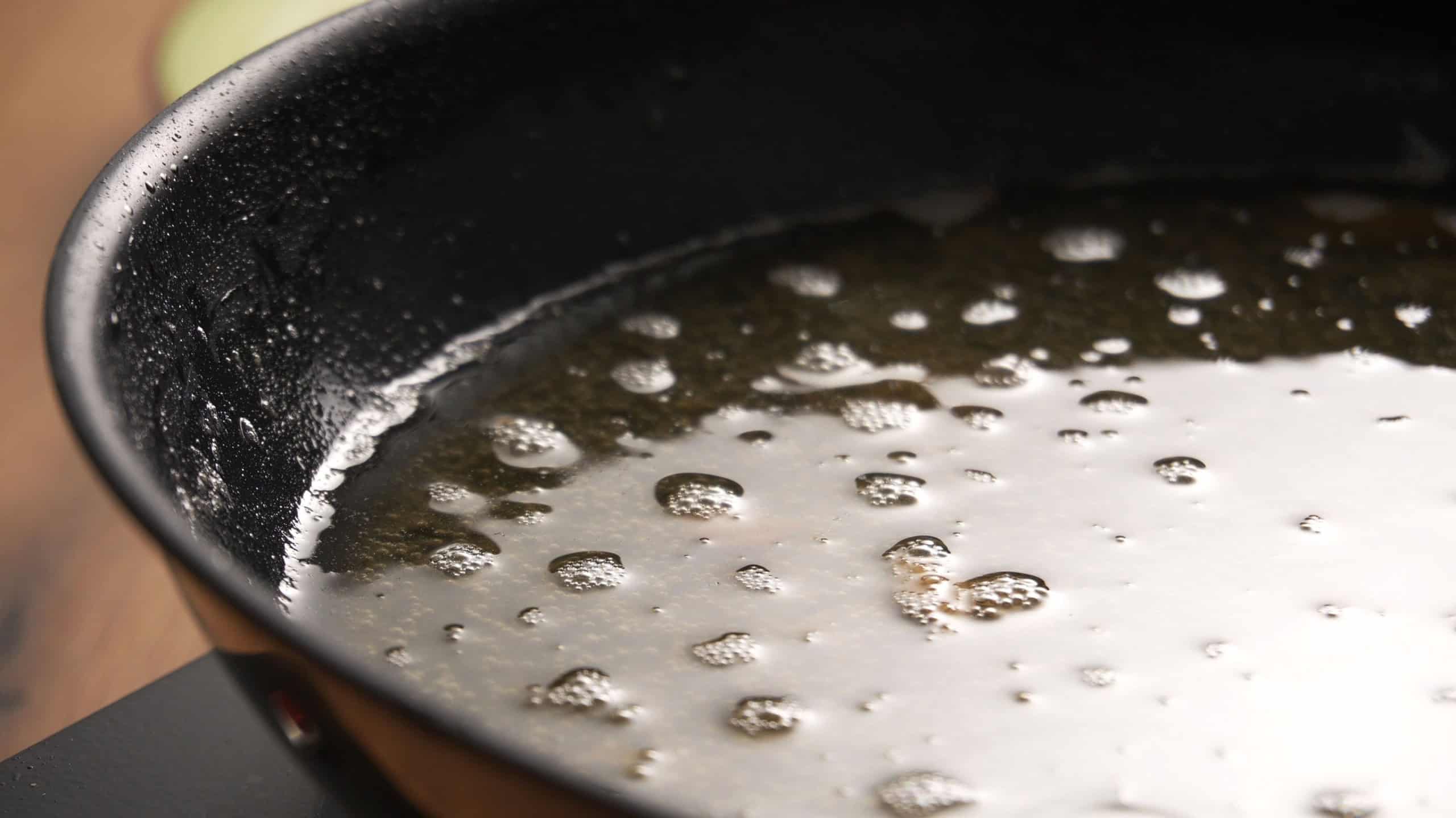 Used Cooking Oil in Frying Pan with bubbles. Close-up, shallow dof.