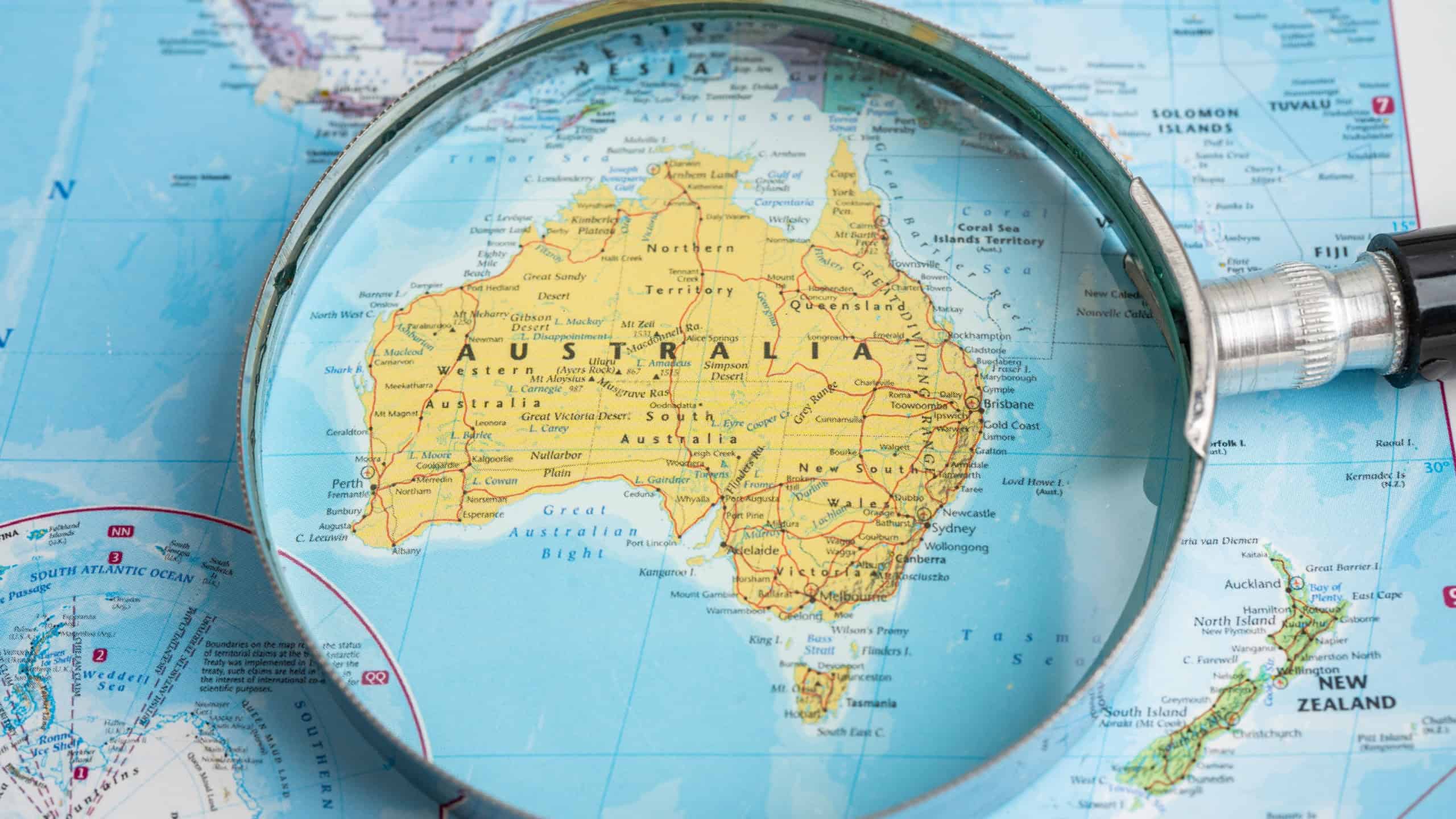 Australia, Magnifying glass close up with colorful world map, travel, geography, tourism and exploration