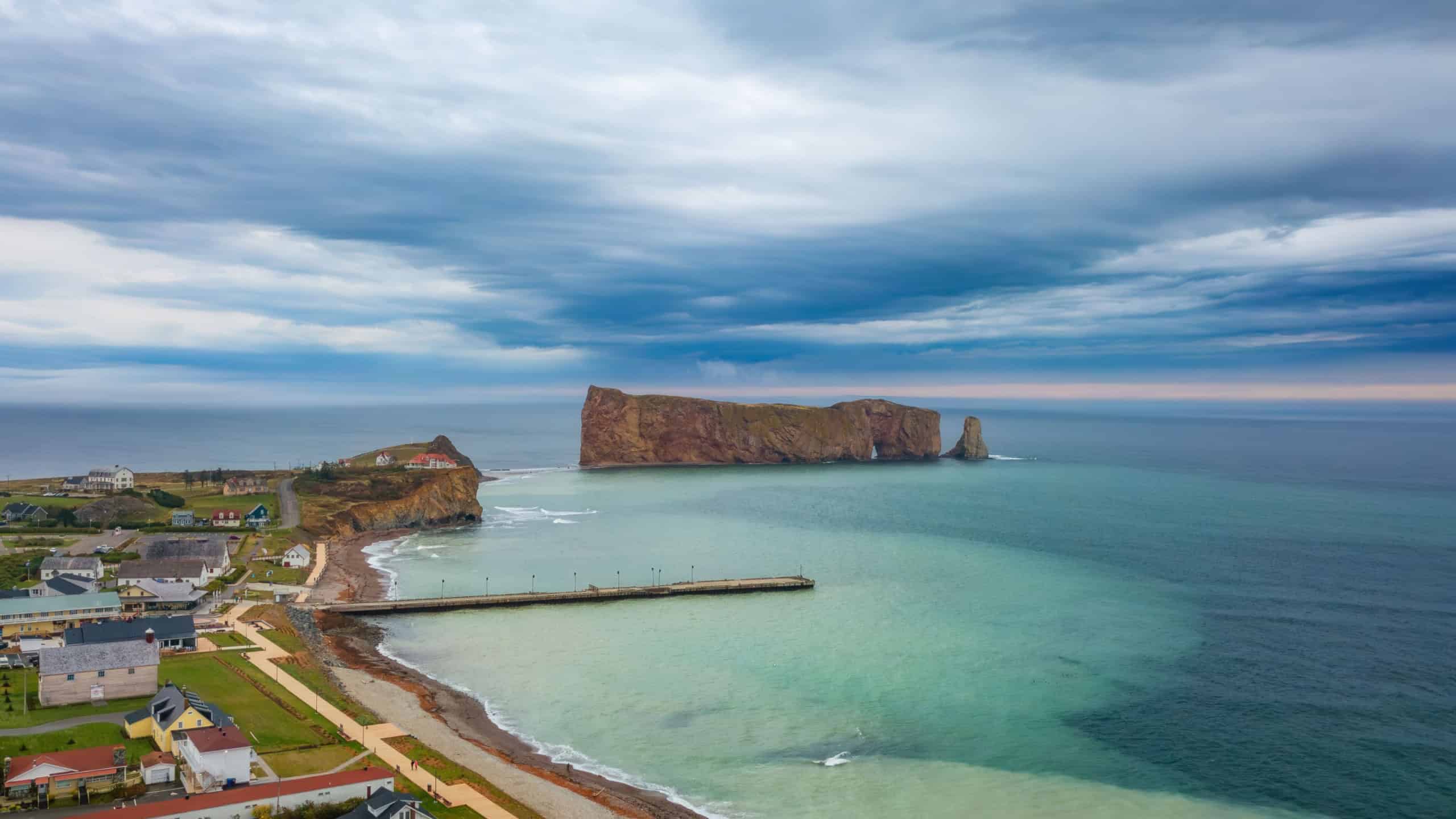 Town on the Atlantic Ocean Coast during a cloudy sunset. Perce, Quebec, Canada. Aerial Panorama
