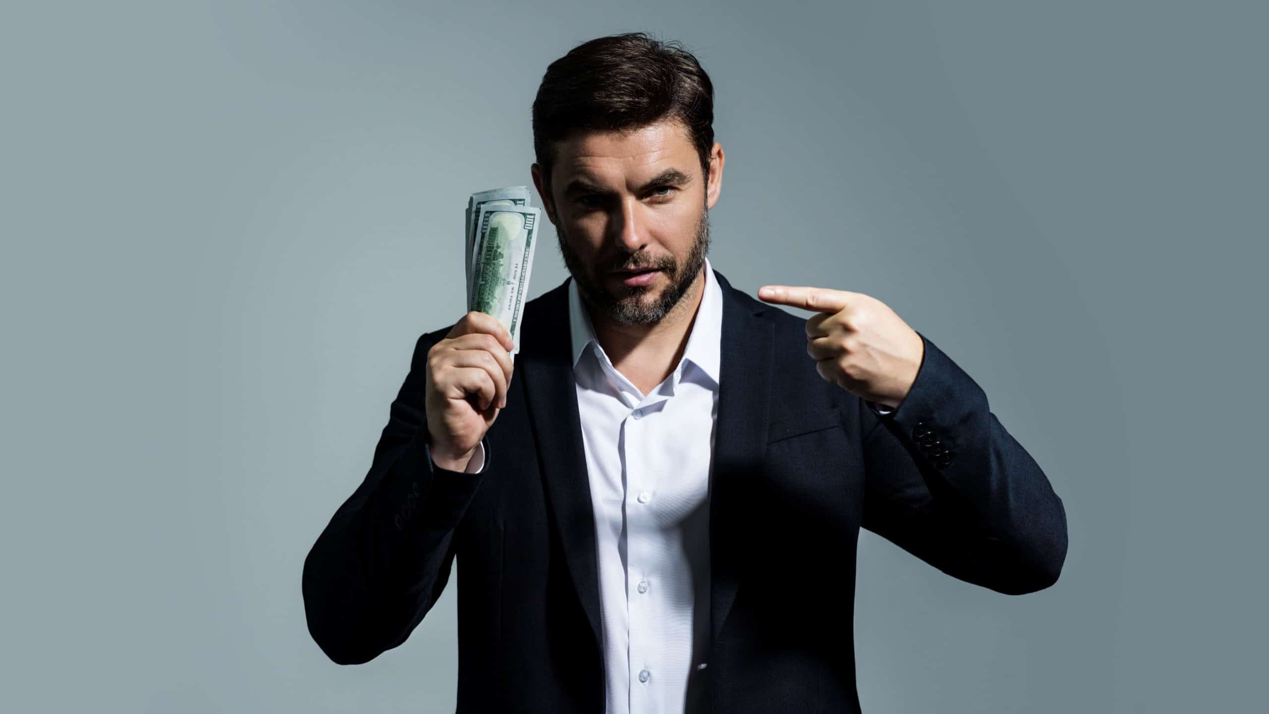 Man with dollars banknotes. Business man holding lots of 100 dollar bills. Easy money credit. Black cash. Payday and payment concept. Profit and richness. Earn money. Businessman successful deal.