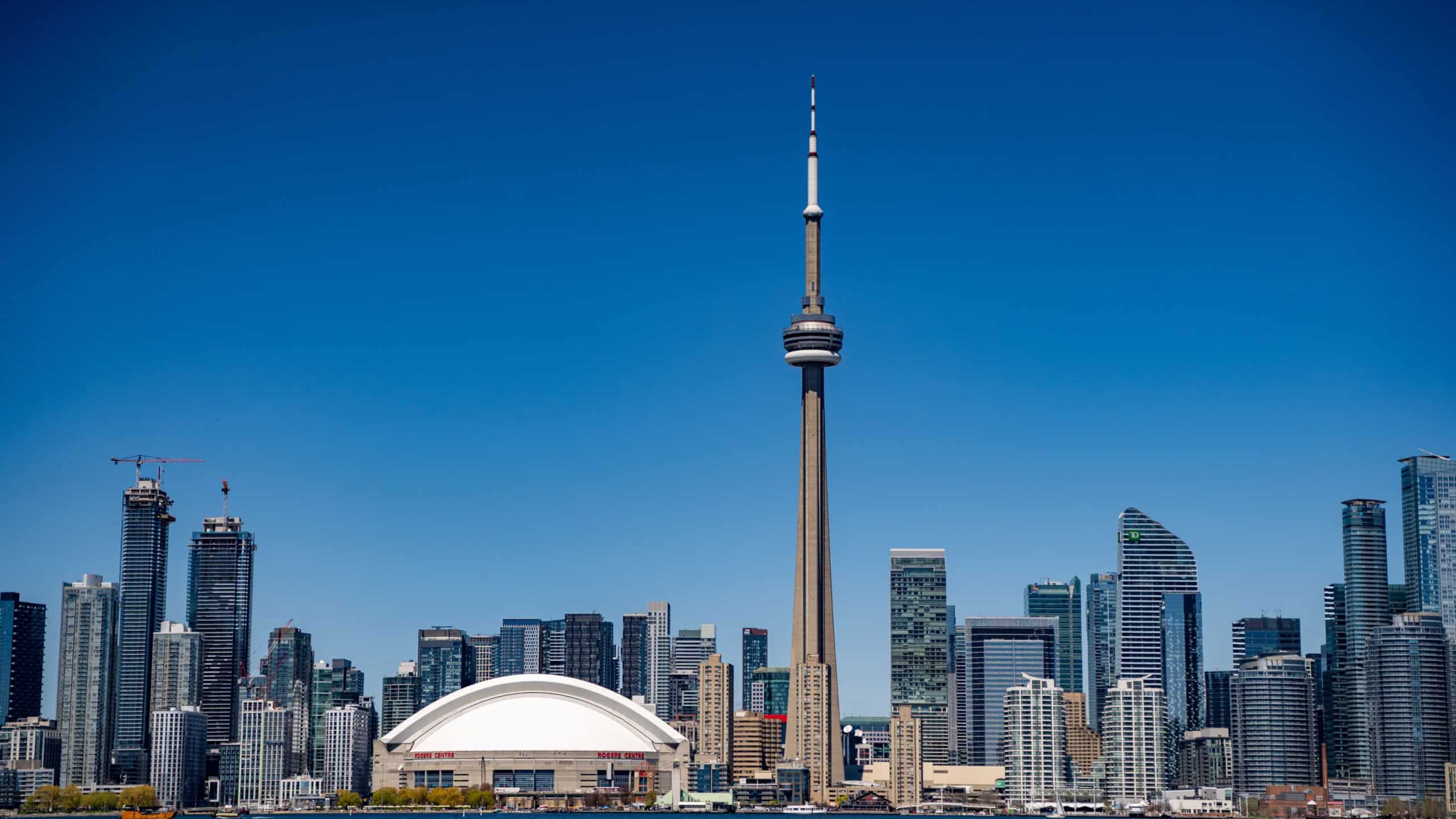 View of the CN Tower and Rogers Center in Downtown Toronto from Toronto Center Island. Toronto, Canada - April 30, 2024.