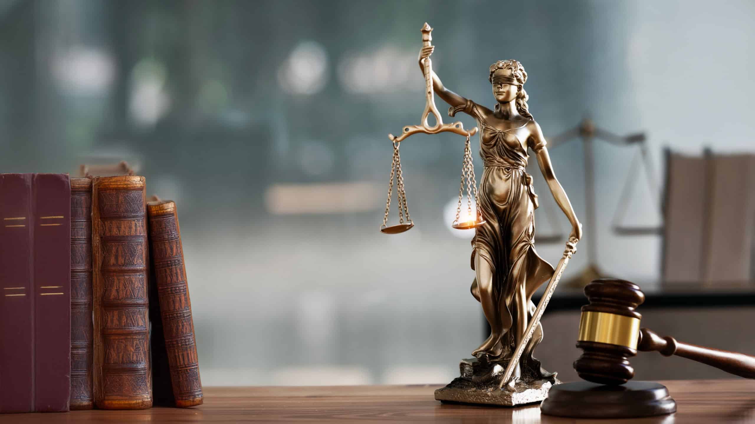 Legal and law concept. Statue of Lady Justice with scales of justice and wooden judge gavel on wooden table. Panoramic image statue of lady justice.
