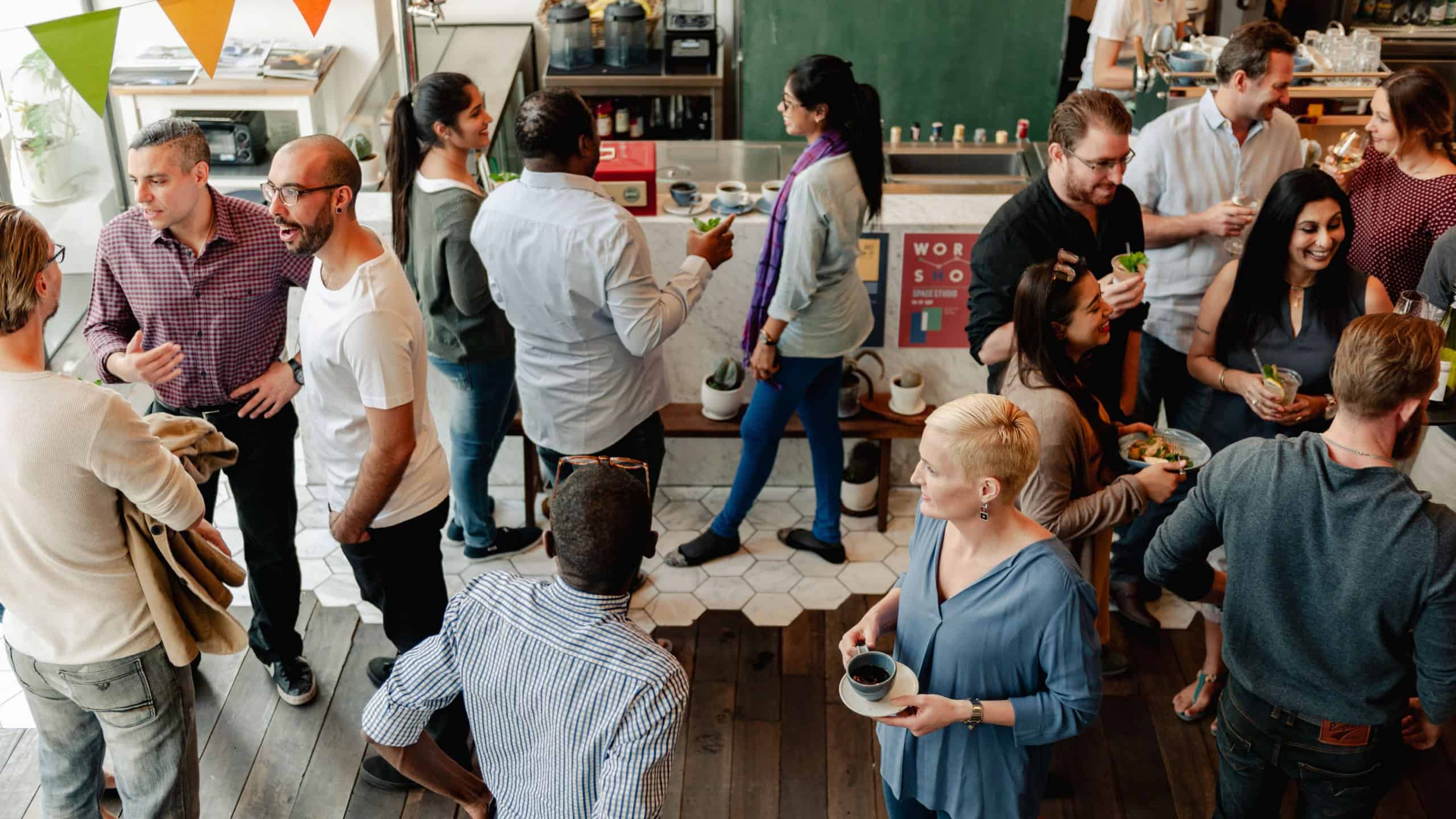 Diverse group of people socializing in cafe. Diverse people chat, enjoy drinks. Lively cafe with diverse people friends socialize. Social gathering event at lively cafe with diverse people friends