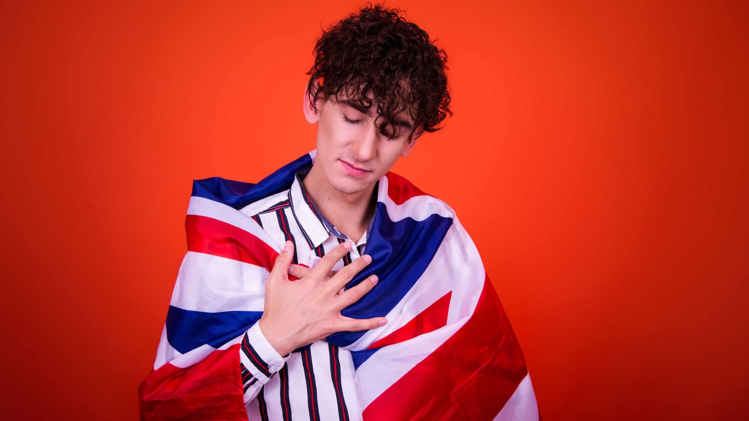 Funny young man posing in studio with flag.