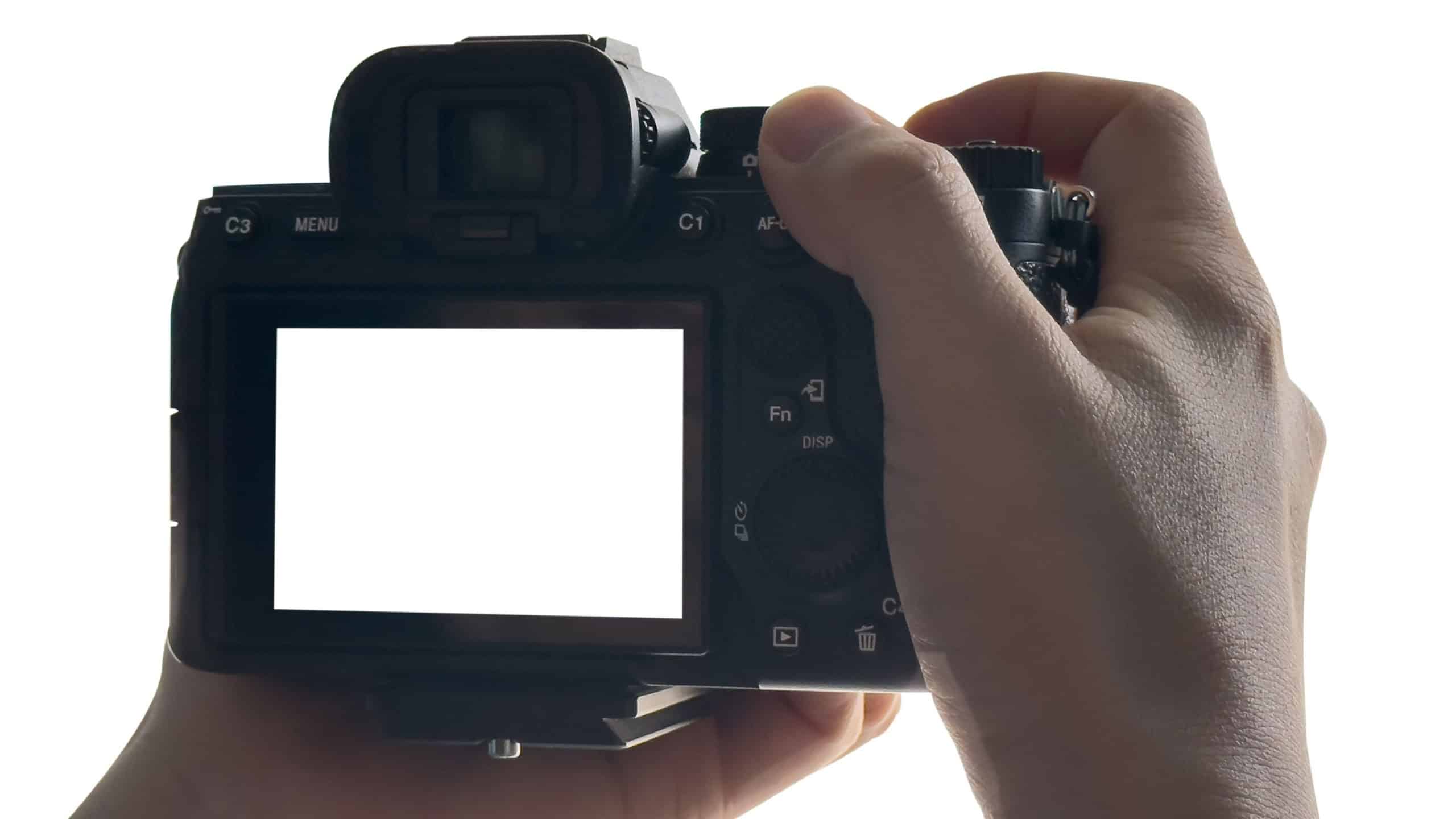 Hand holding Mirrorless camera with white screen isolated on white background. clipping path