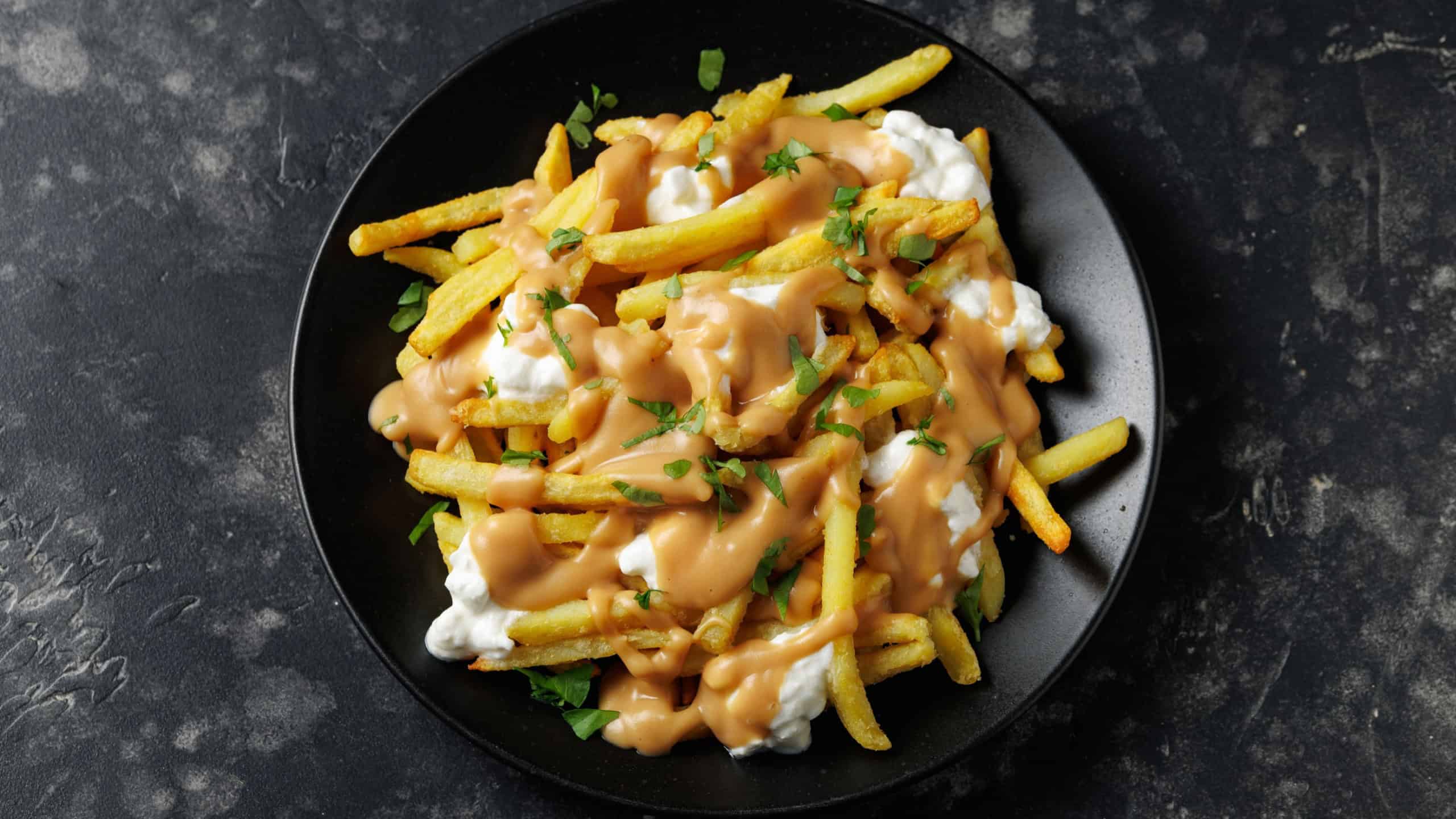 Delicious traditional canadian dish poutine gravy and fries with cheese. Rotating video.