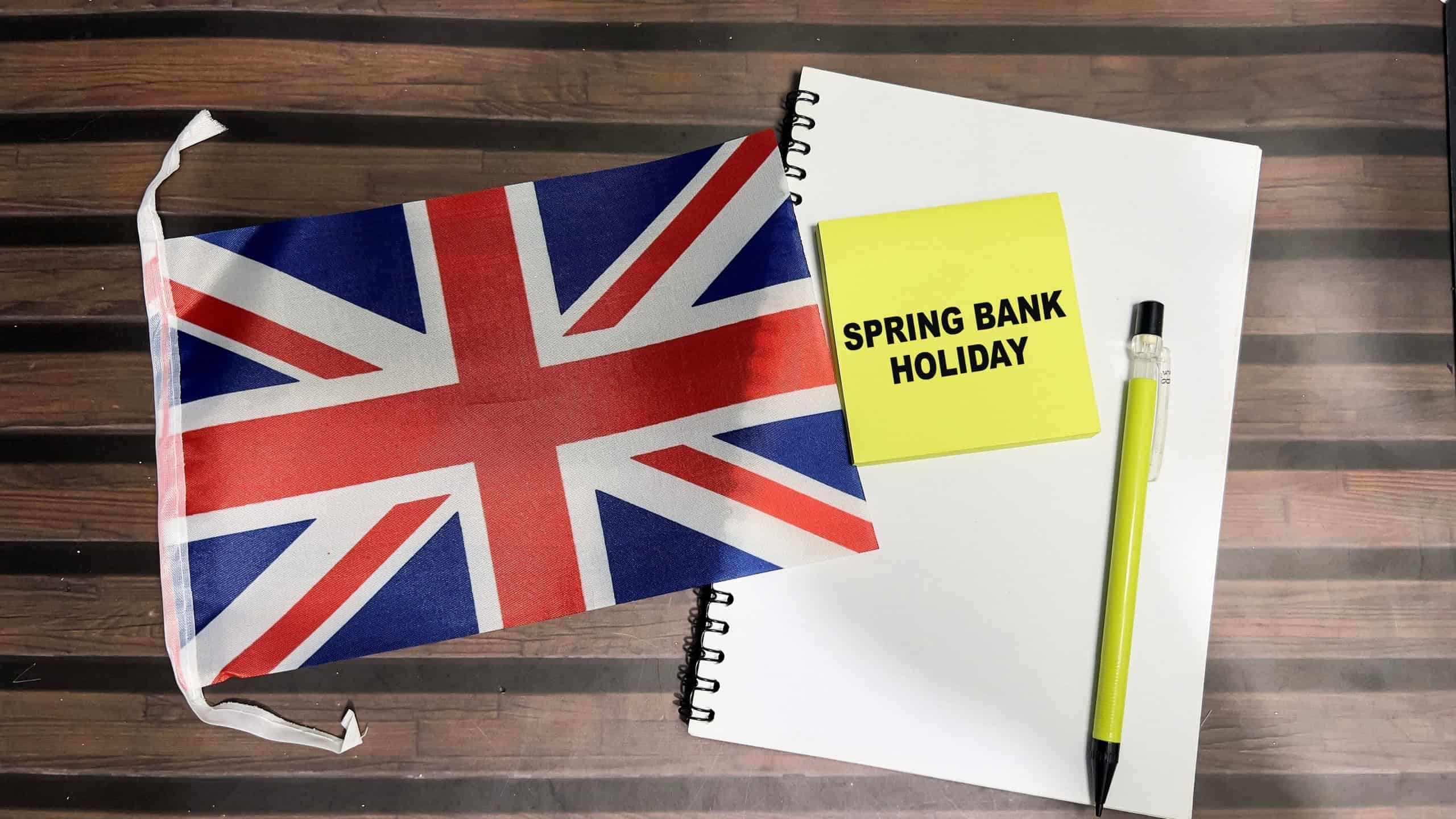 Concept of Spring Bank Holiday write on sticky notes and Flag of England isolated on Wooden Table.