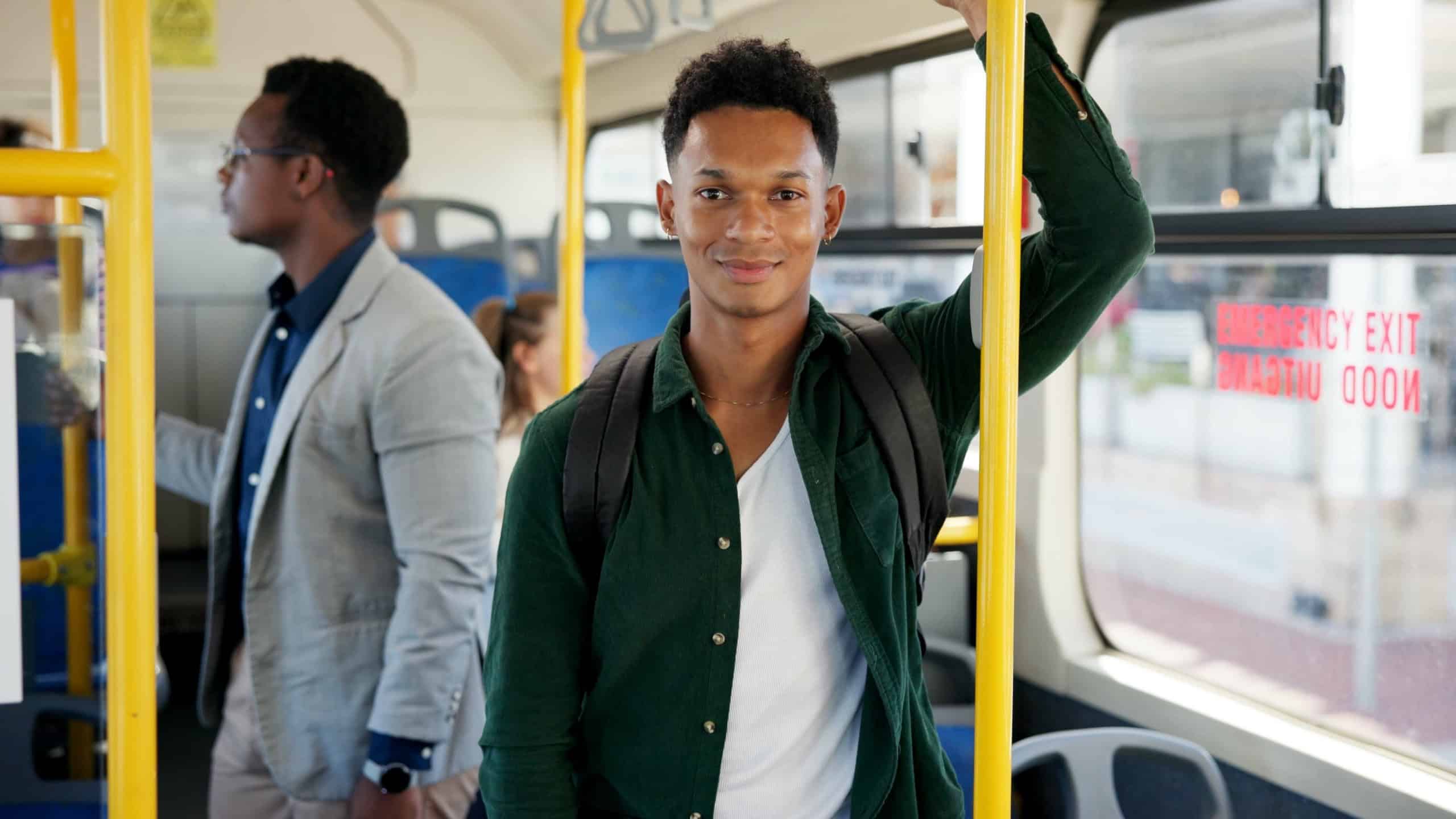 Student, portrait and man travel on bus for morning commute, college destination and smile for journey. Passenger, happy person and backpack on public transport for education and ride to university
