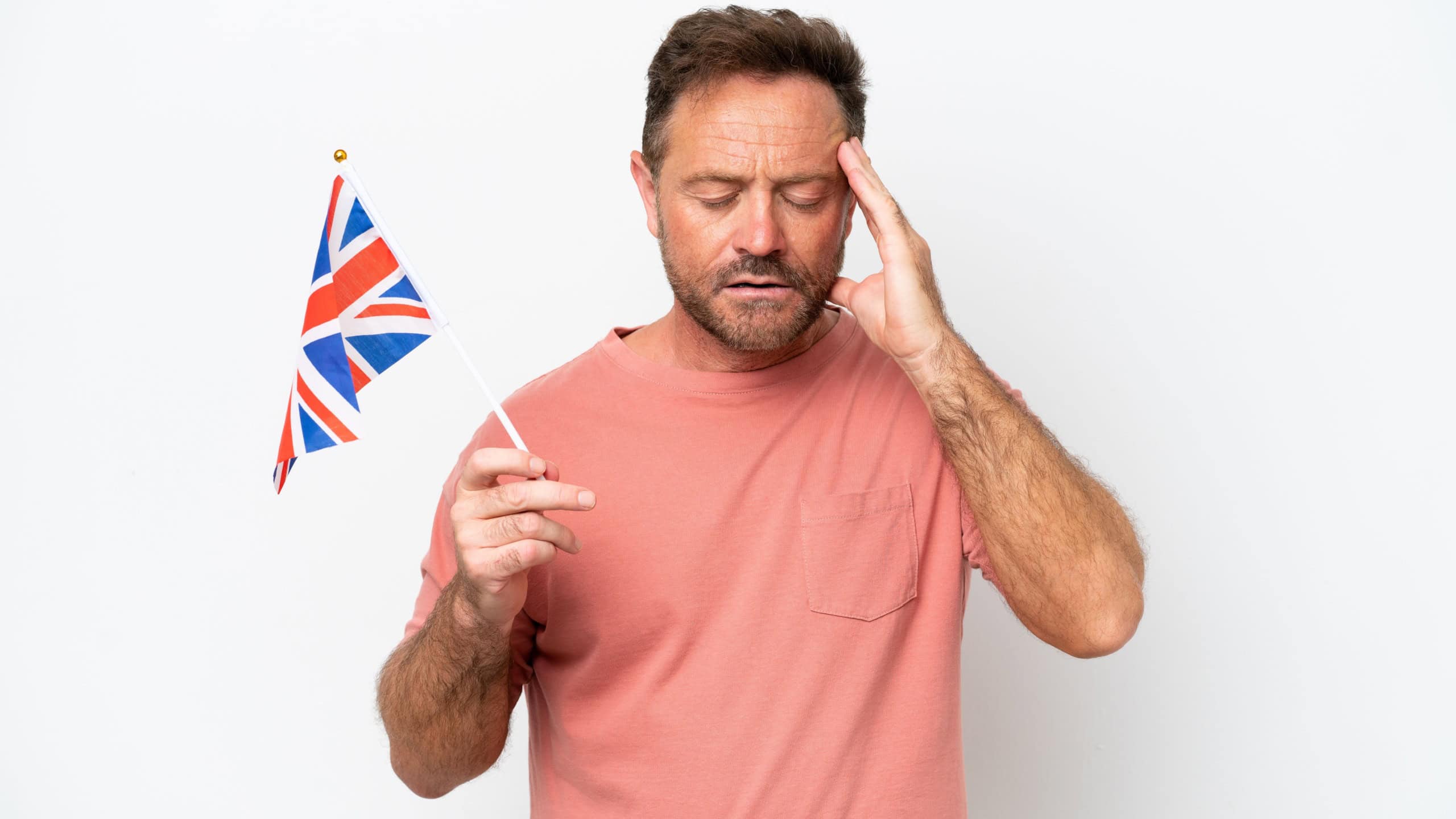 Middle age caucasian man holding English flag isolated on white background with headache