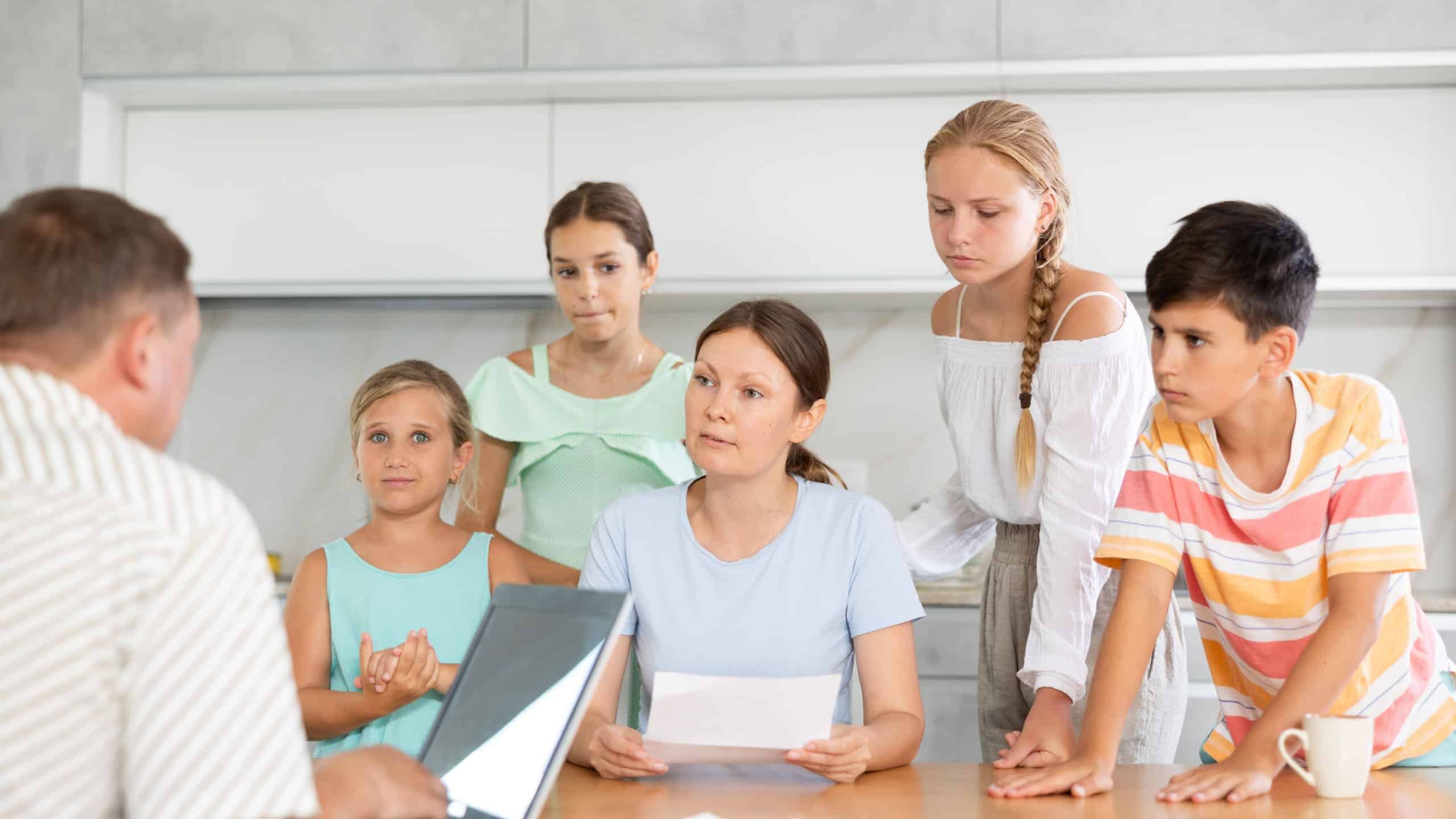 Social services officer visiting woman with multiple children to inform about refusal of benefit