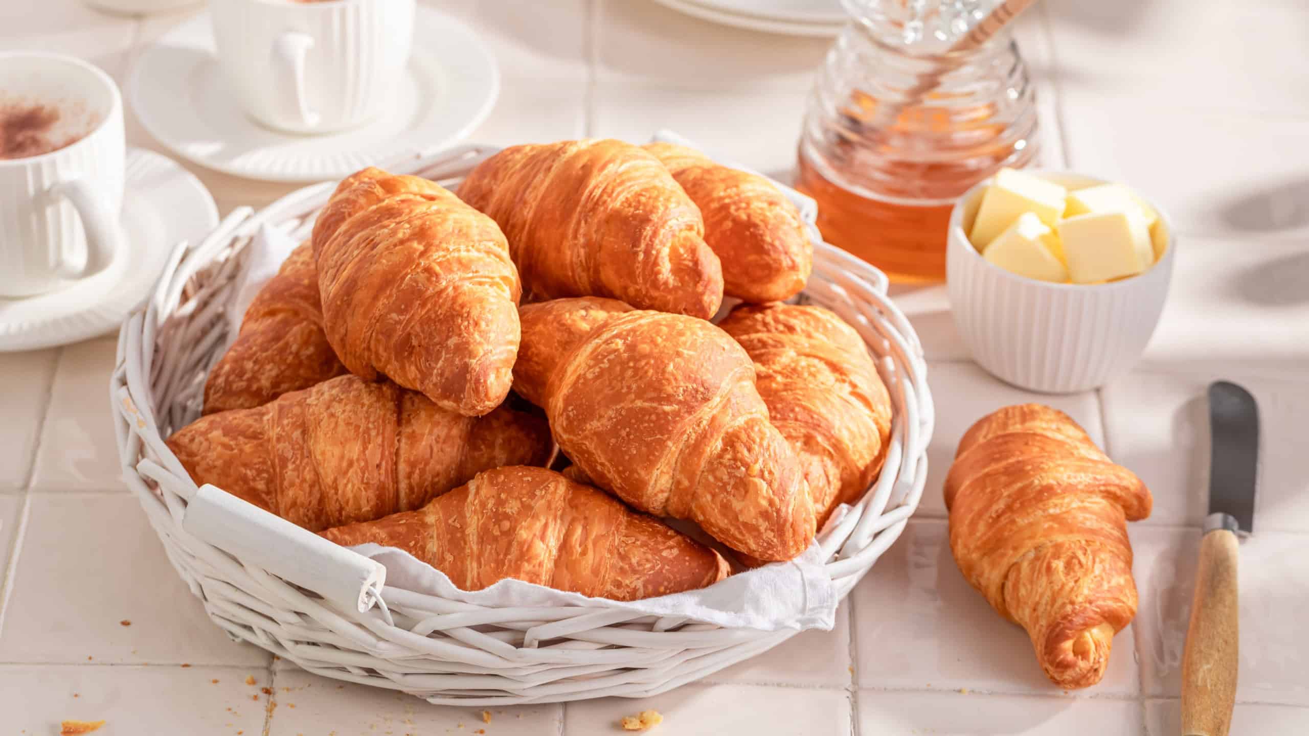 Crunchy and tasty french croissants with honey for breakfast. Breakfast with coffee, honey and butter.