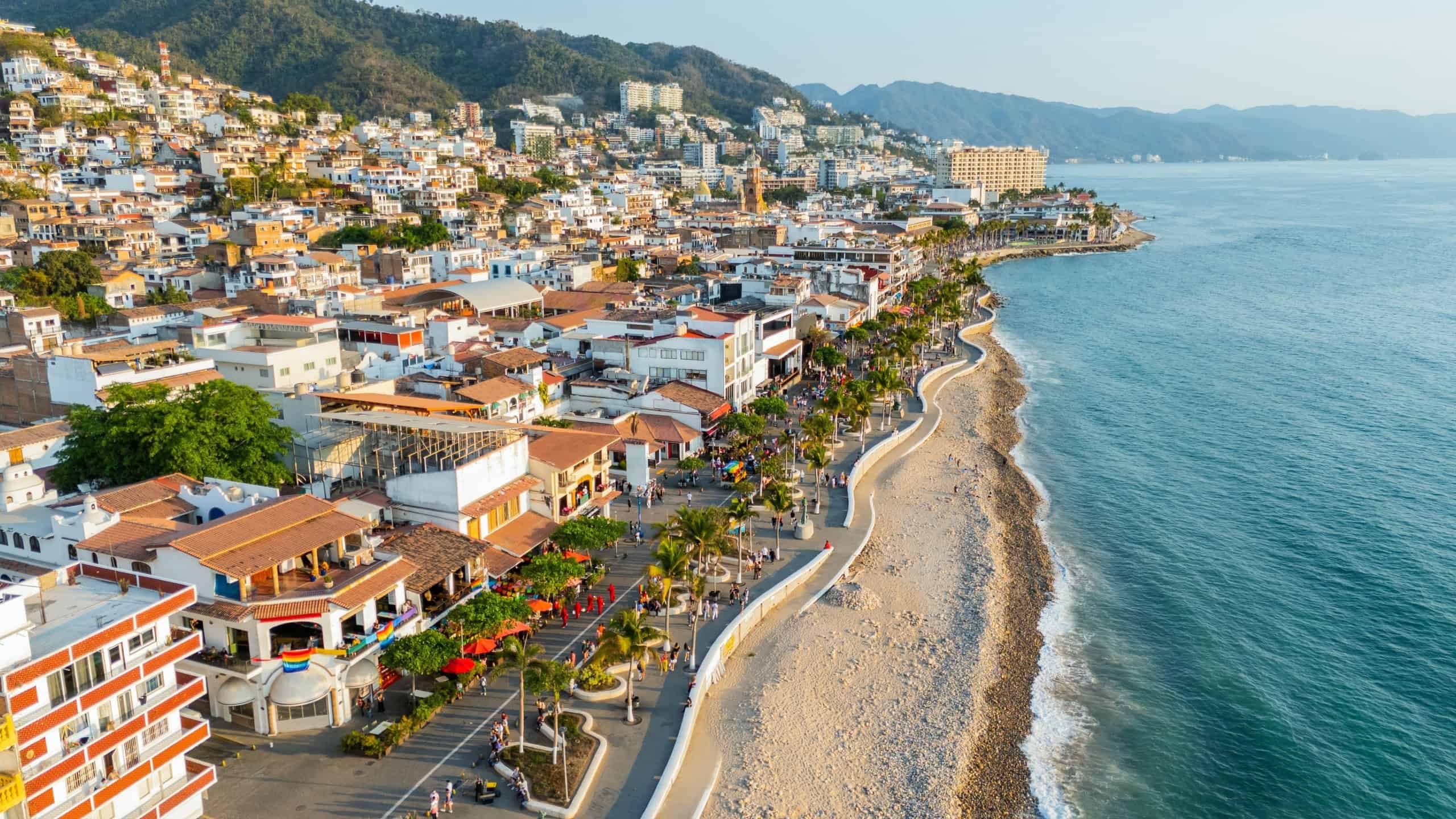Aerial view of the boardwalk in puerto vallarta, mexico, during a vibrant sunset, showcasing the city's beauty and the pacific ocean. LGBT Parade