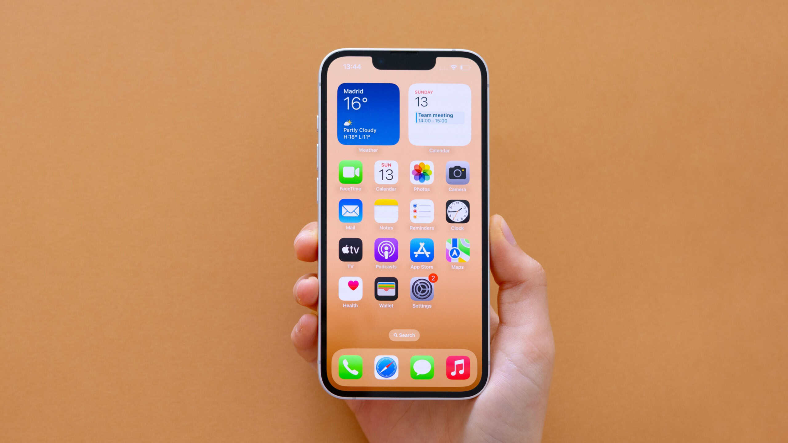 Madrid, Spain - April 13, 2025: The latest Apple iPhone 16e mobile phone in hand on beige background.