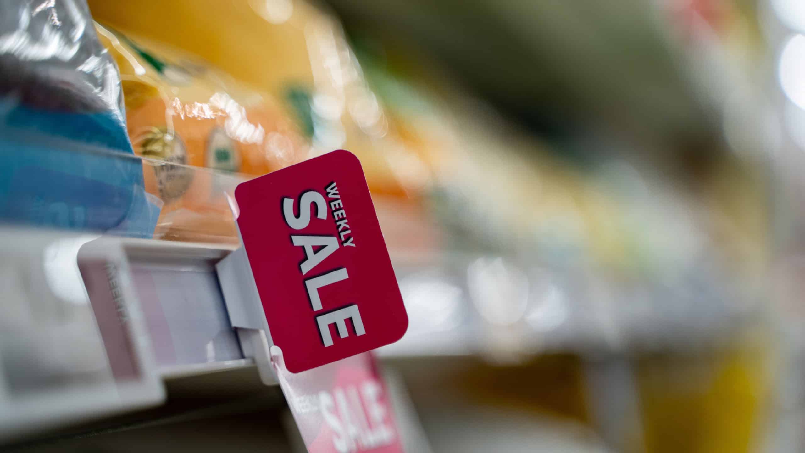 Weekly sale sign on supermarket shelf in grocery store.