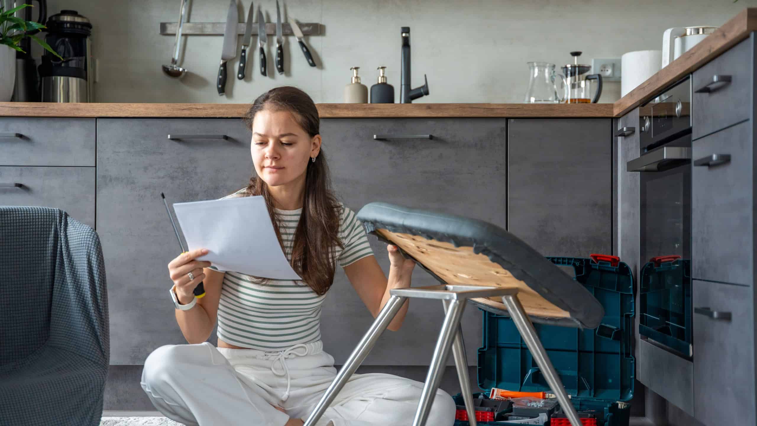 Frustrated young woman sitting on the floor reading instructions while assembling a chair. Concept of confusion and challenge in do it yourself project. High quality photo