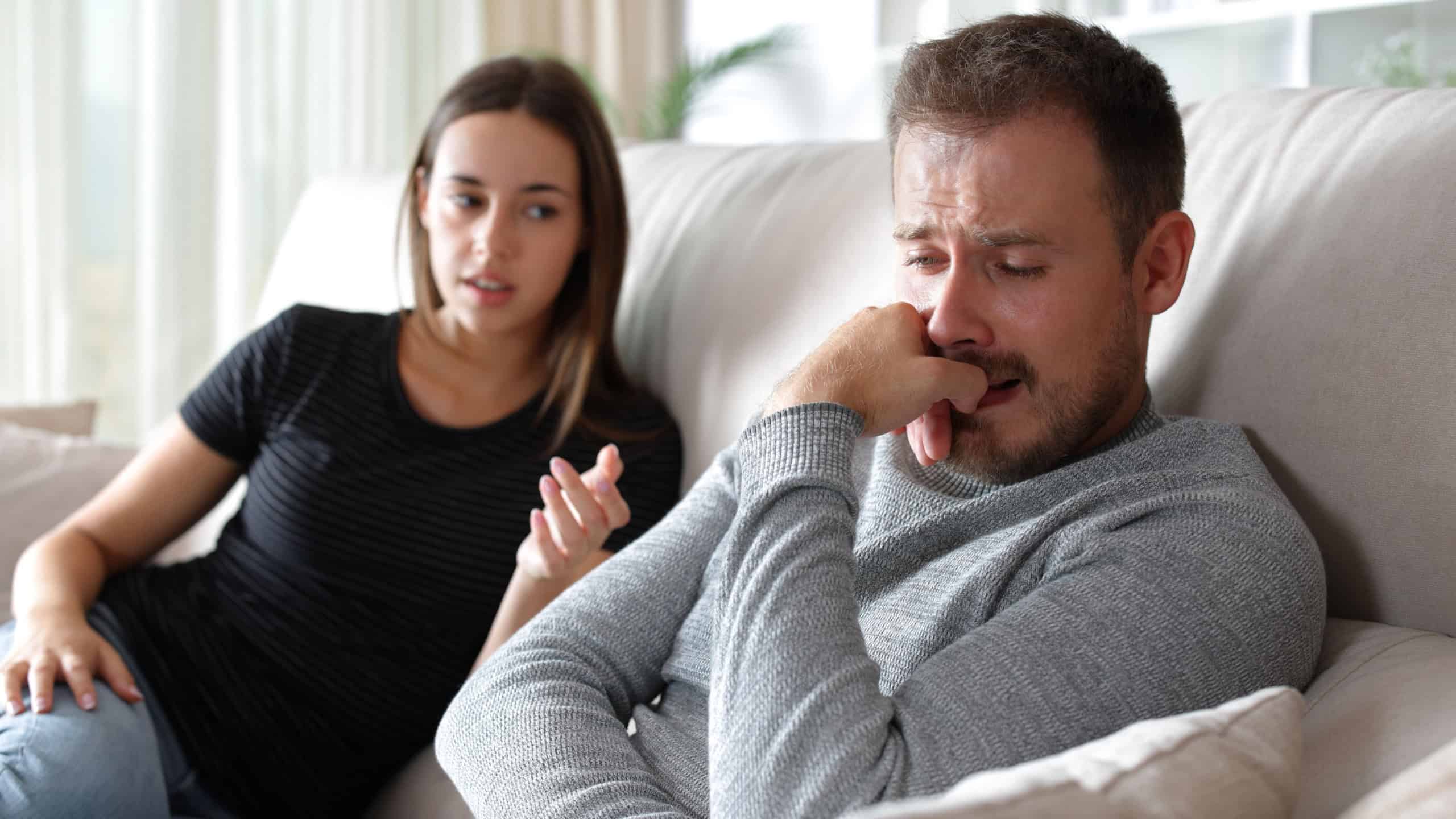 Sad man complaining and woman counseling him at home