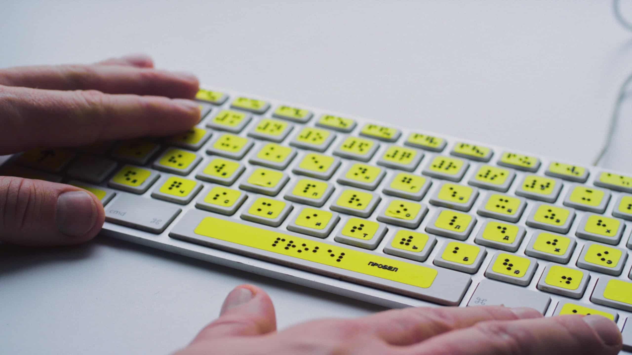 Blind person man hands using computer braille keyboard or terminal a technology assistive device for persons with disabilities. Palms moving tactile keys, creating text for visually impaired people.