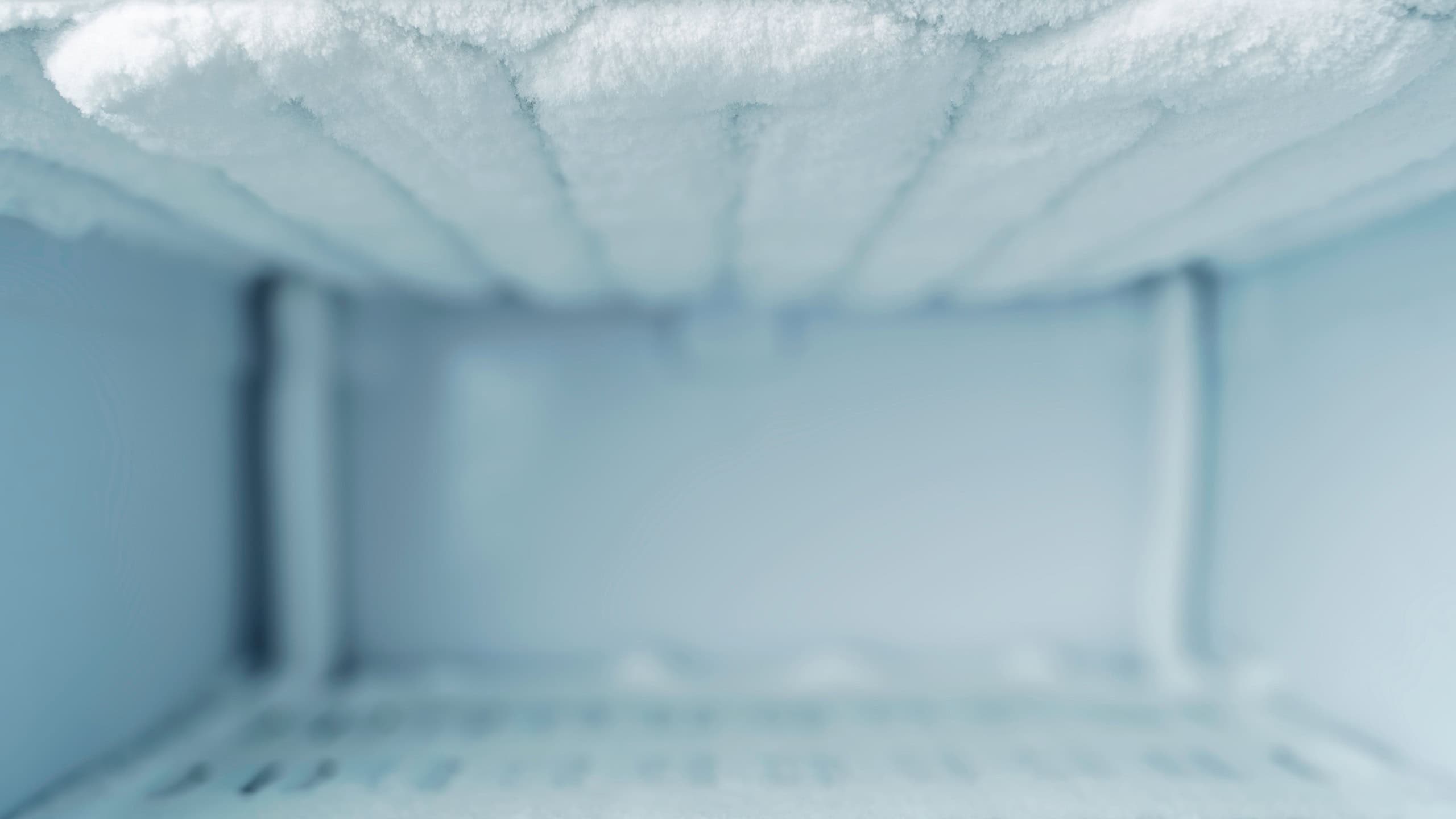 Empty frosty freezer interior with ice buildup and copy space, background for freezing services, cold storage ads and offers.