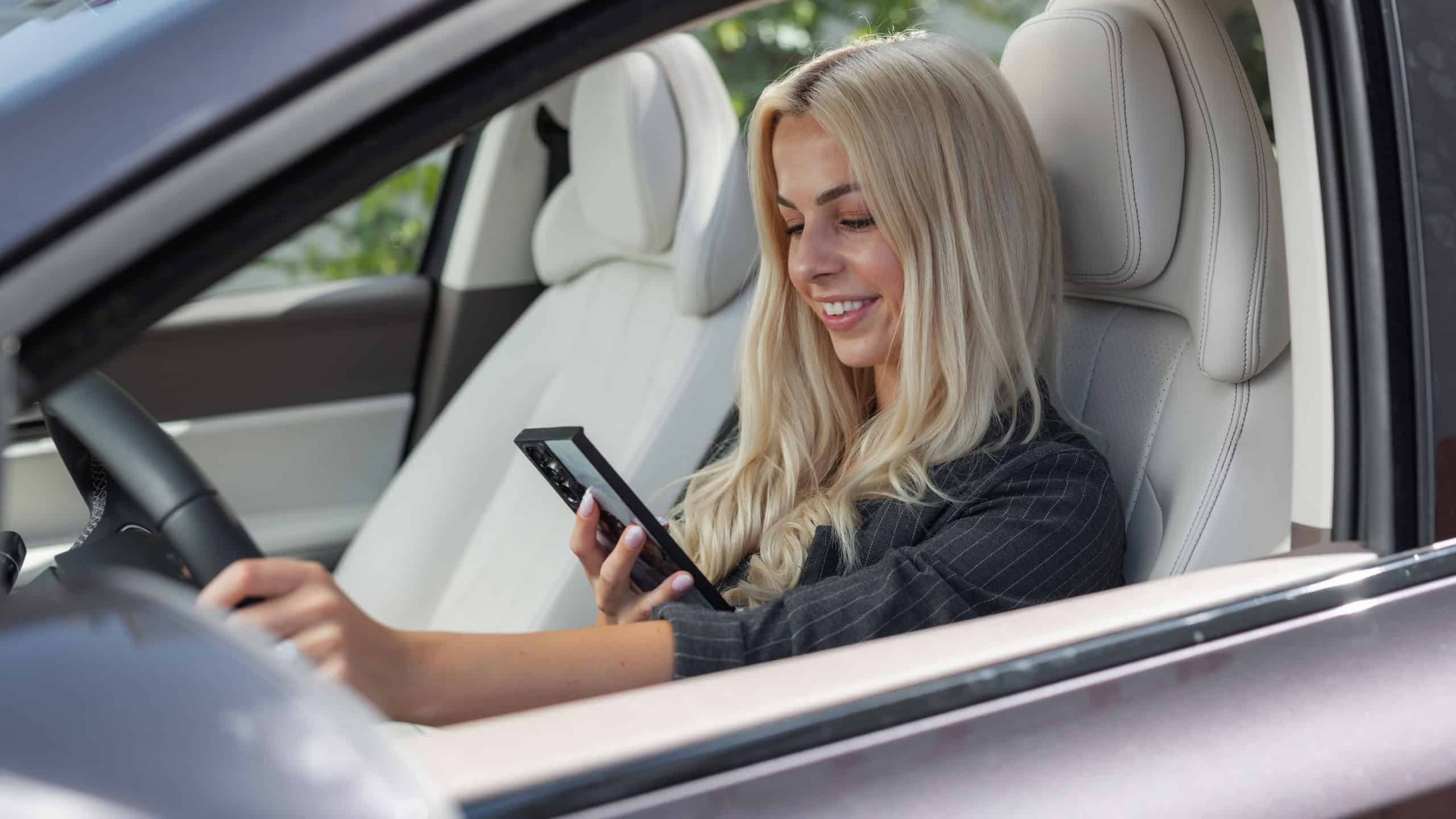 Woman is focused on their phone while driving a car and texting.