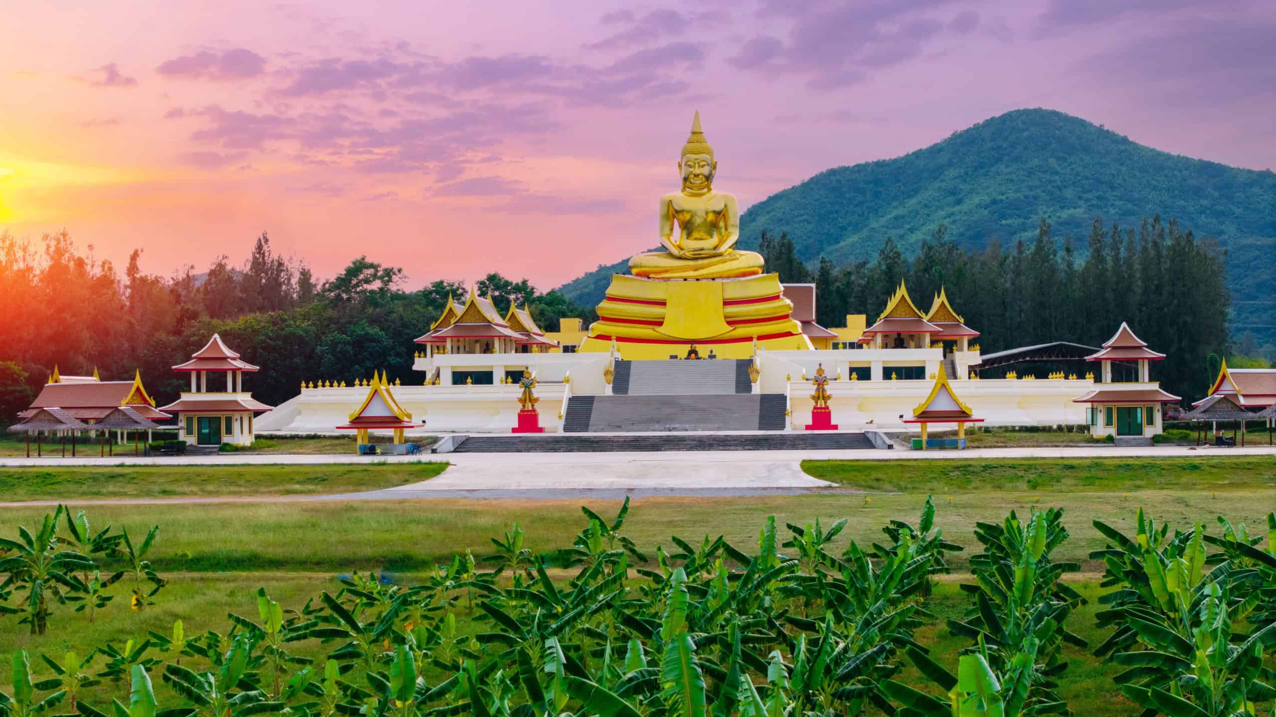 Majestic huay mongkol temple at sunset in hua hin, thailand with serene mountain backdrop.