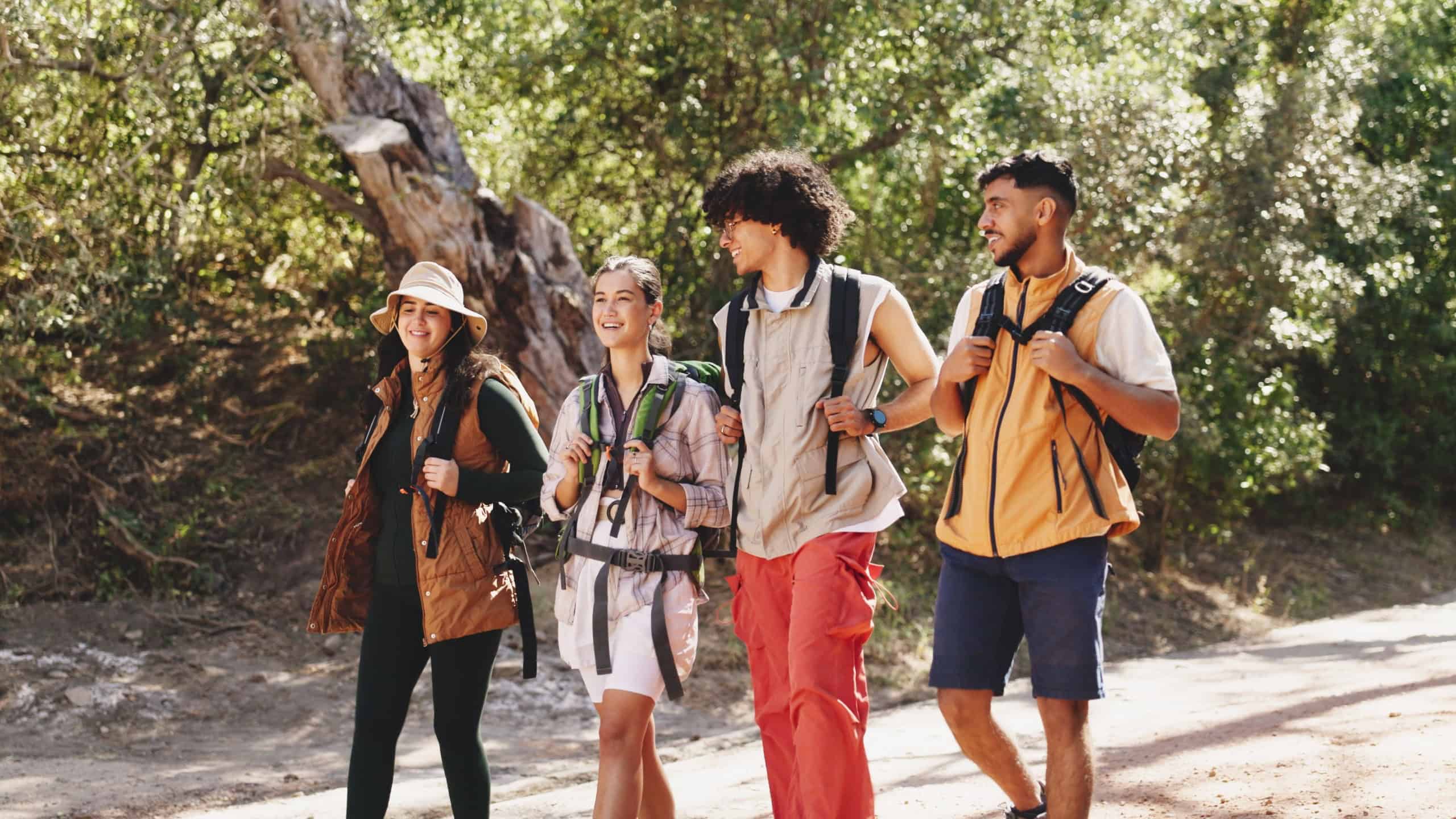 Conversation, hiking and travel with group of friends outdoor in forest for hobby or journey. Backpacking, trekking and walking with hiker people on trail in nature together for adventure or bonding